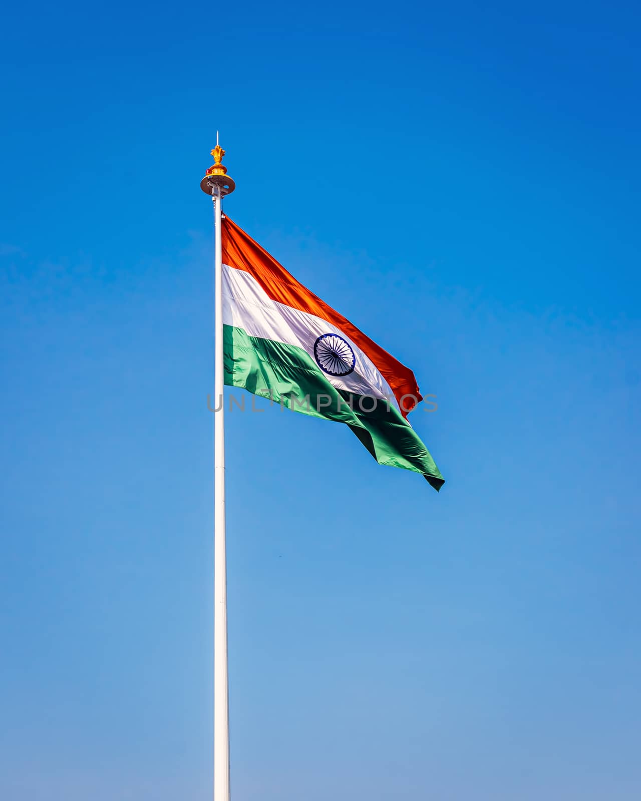 Indian National Flag , flying high in the sky on a clear blue background.