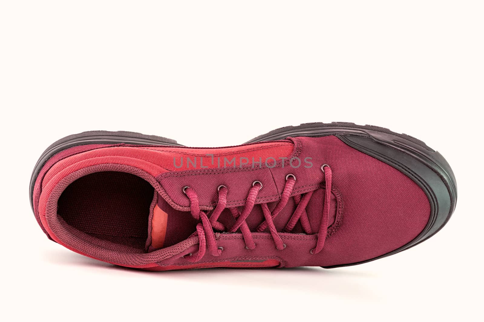 one right cheap red fabric hiking shoe isolated on white background.