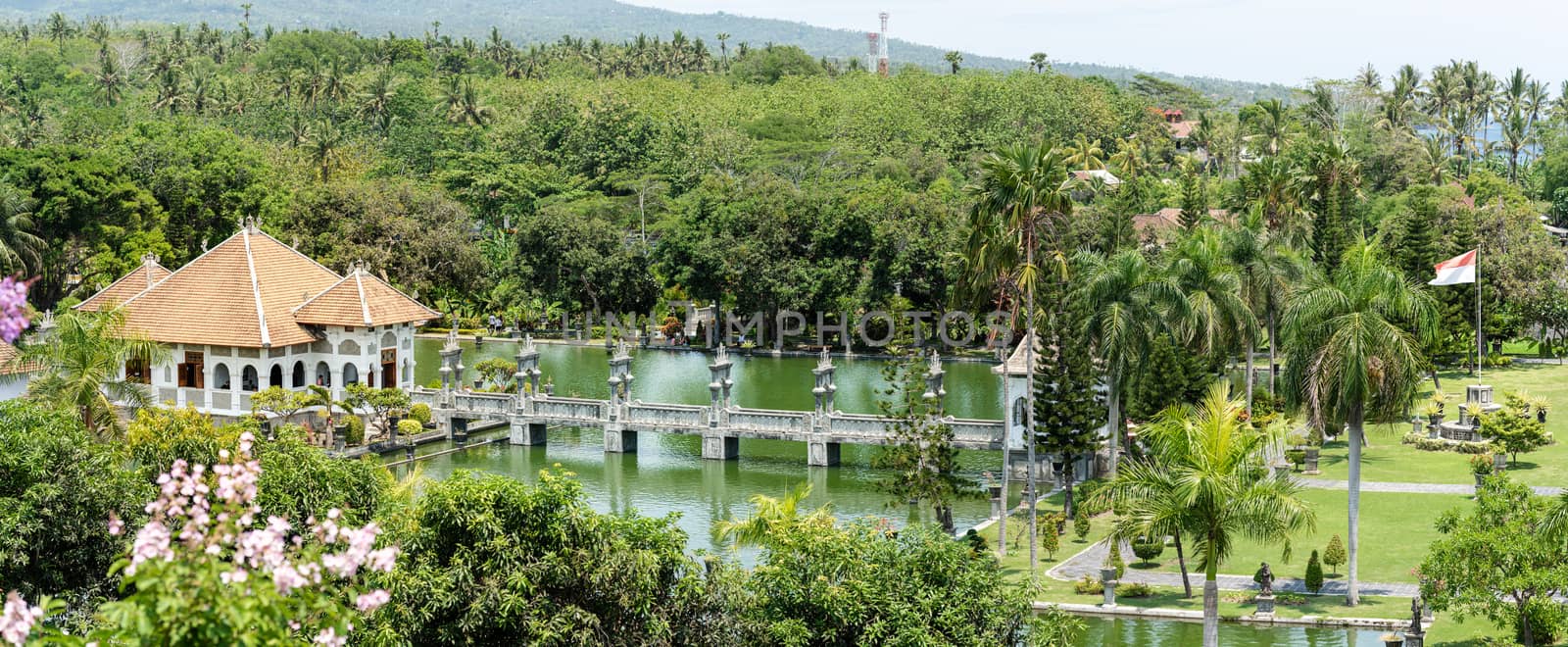 Taman Ujung Water Palace is a popular landscaped garden with a pond and water pavilions, ornate with statues of Balinese folklore and typical trees, originally a royal palace near Ubud, Bali Island, Indonesia
