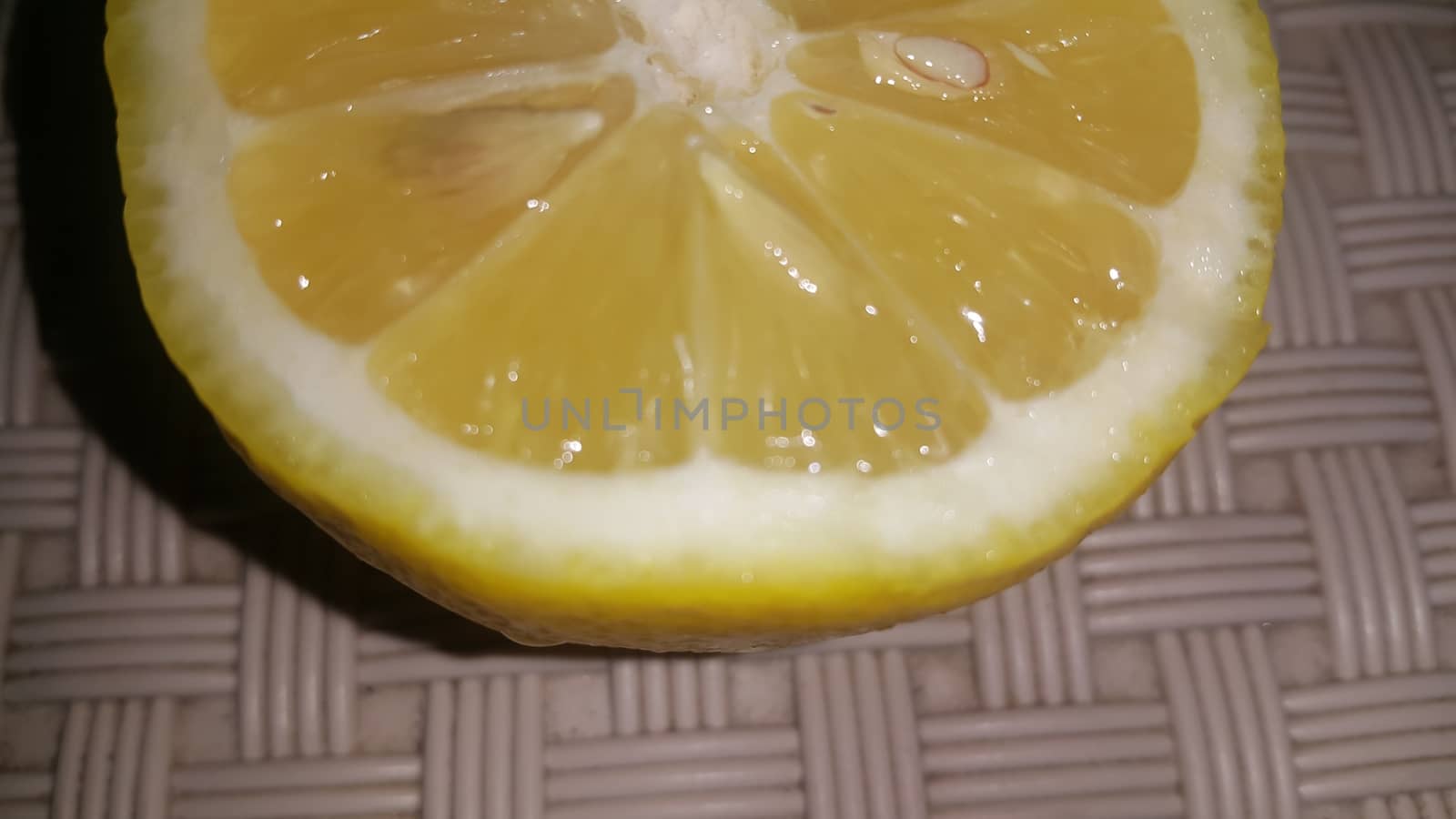 Fresh lemon slices with yellow peelings placed on a grey floor. Top view of fresh juicy lemon slice background