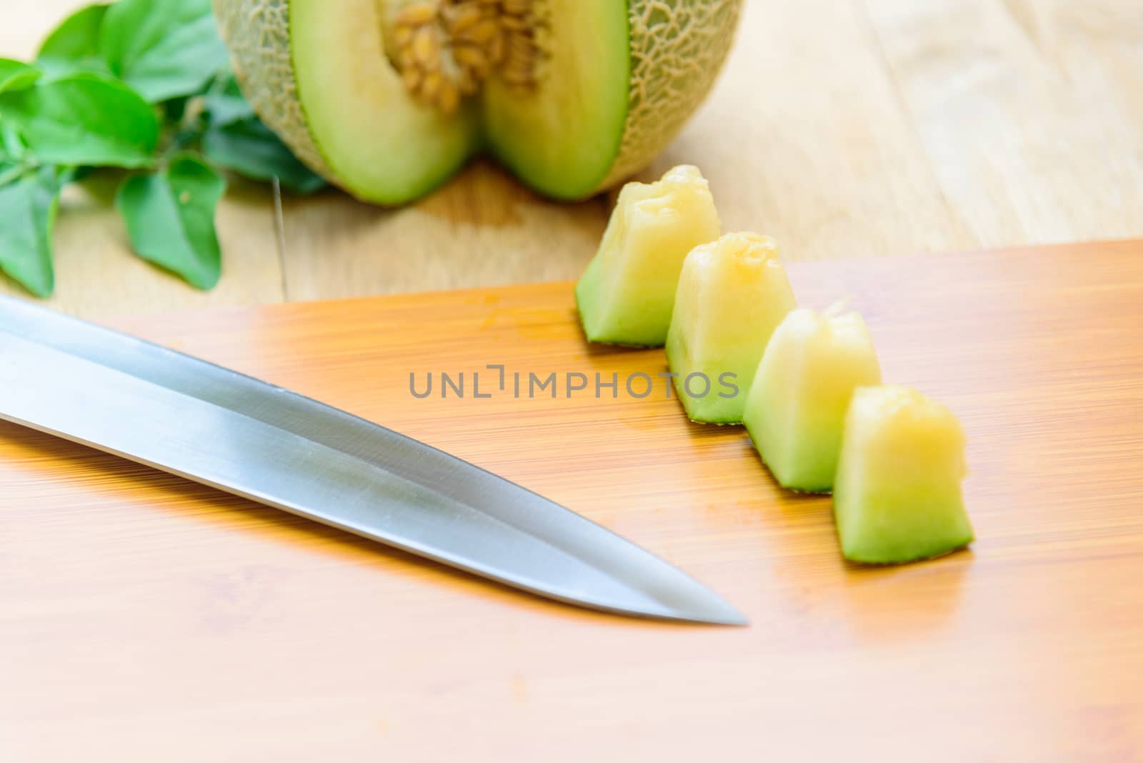 Fresh green melon on wood plate