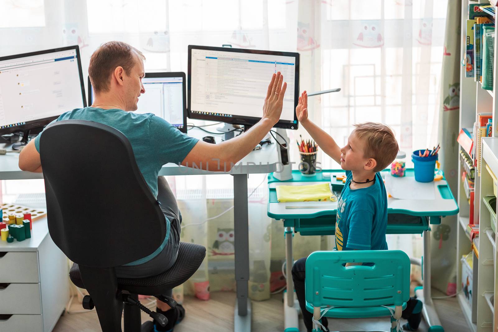 Father with kid trying to work from home during quarantine. Stay at home, work from home concept during coronavirus pandemic