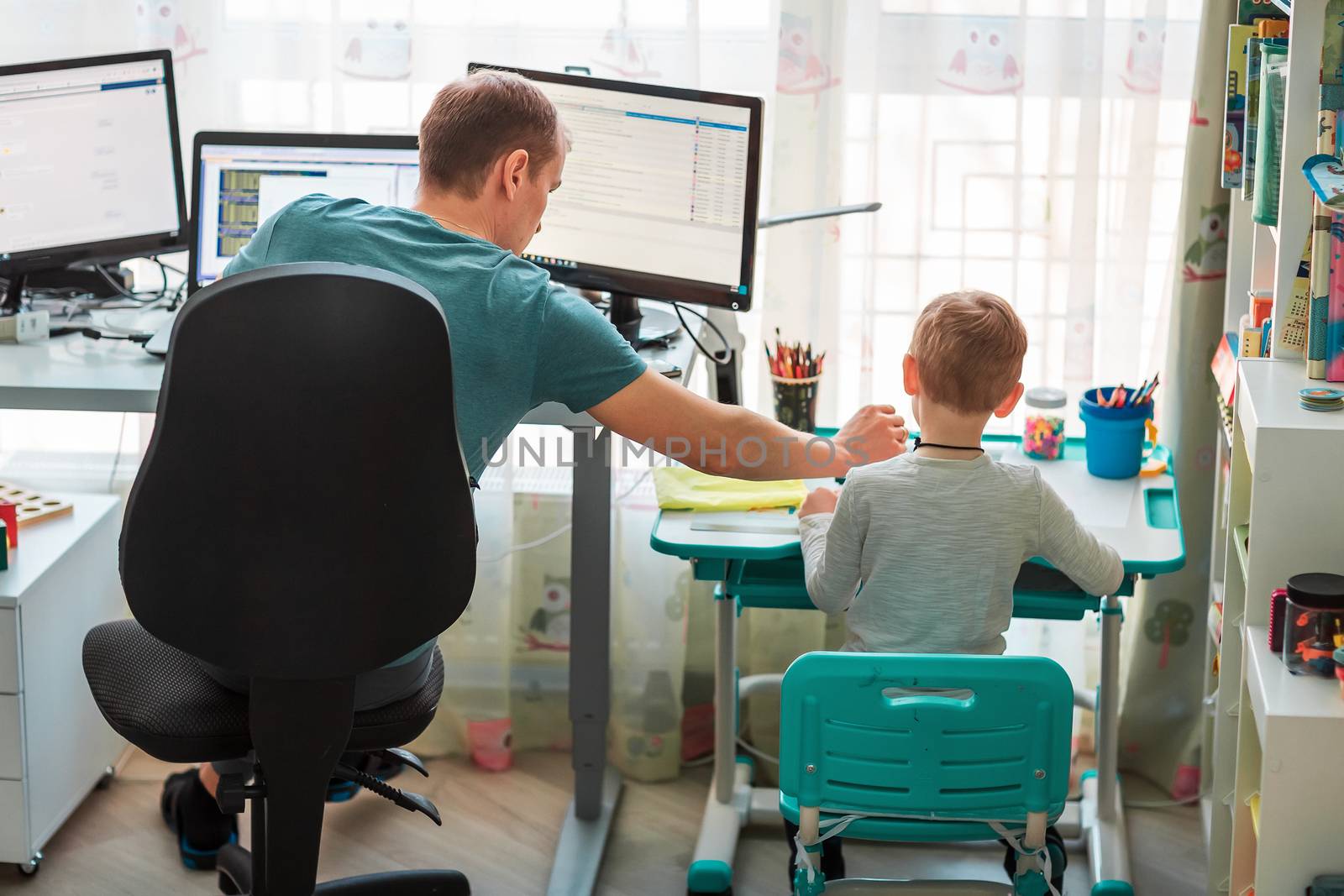 Father with kid trying to work from home during quarantine. Stay at home, work from home concept during coronavirus pandemic