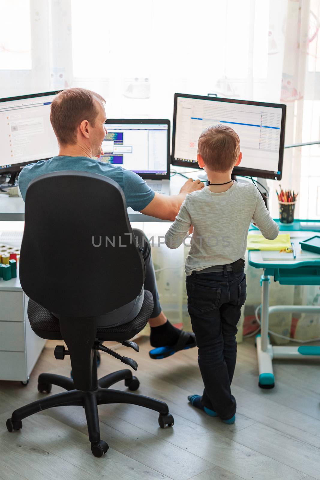 Father with kid trying to work from home during quarantine. Stay at home, work from home concept during coronavirus pandemic