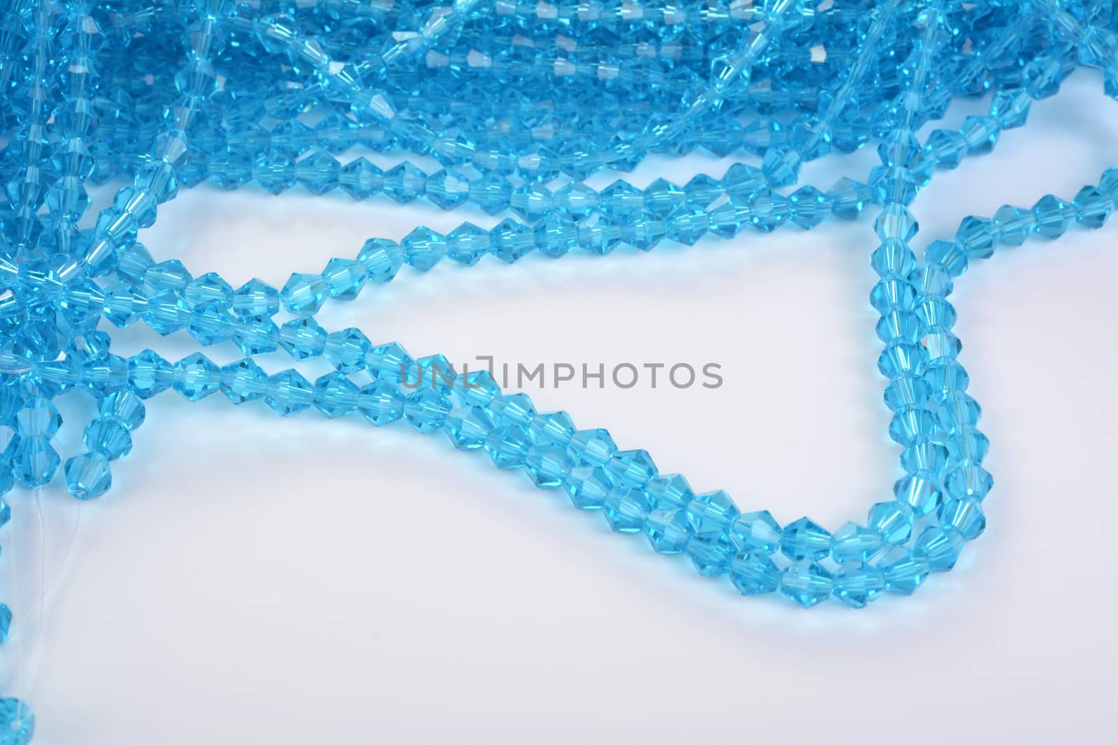 Beautiful Light Blue Glass Sparkle Crystal Isoalted Beads on white background. Use for diy beaded jewelry. Space for text