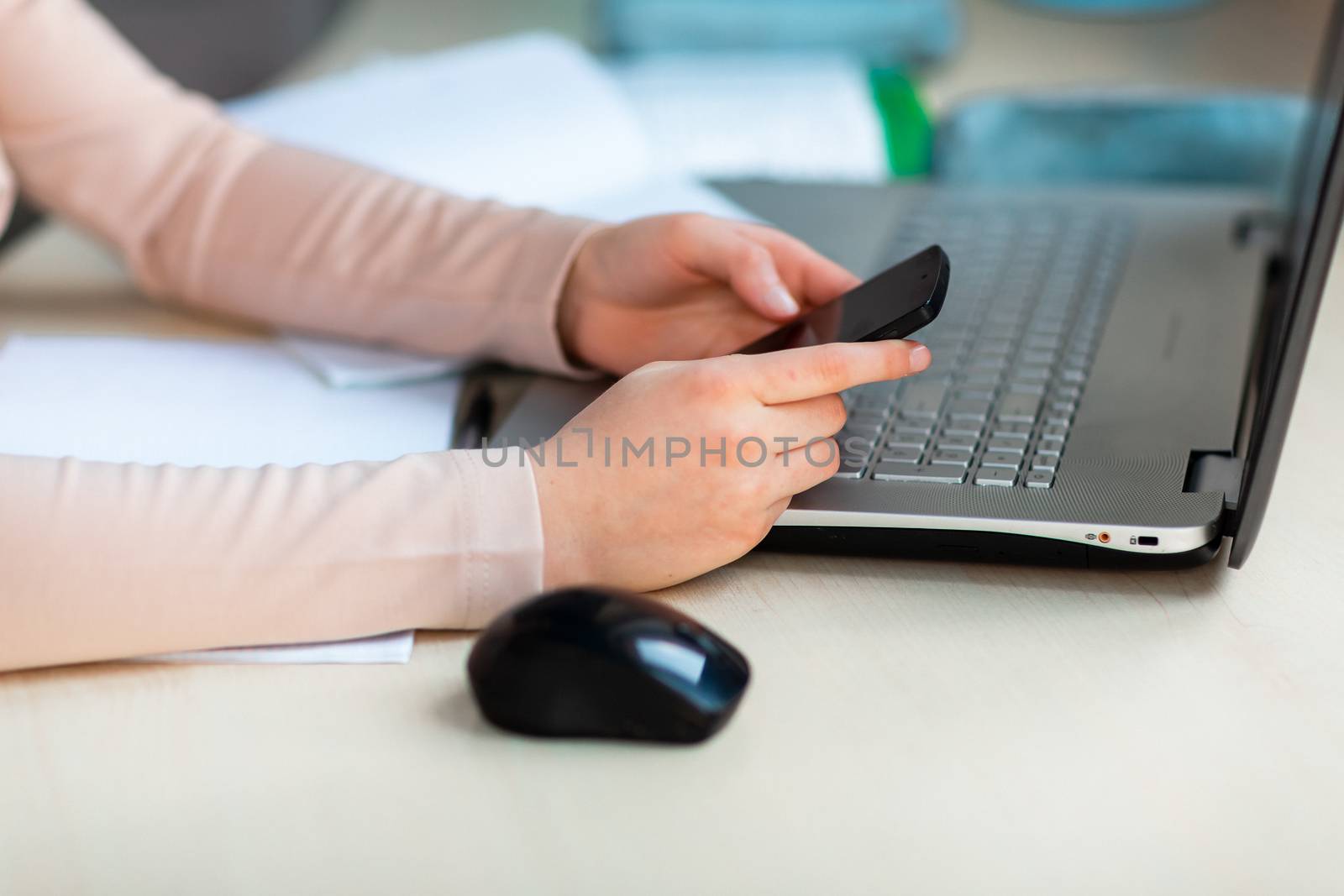 Close up of young school girl working at home in her room with a laptop and class notes studying in a virtual class. Distance education and e-learning, online learning concept during quarantine