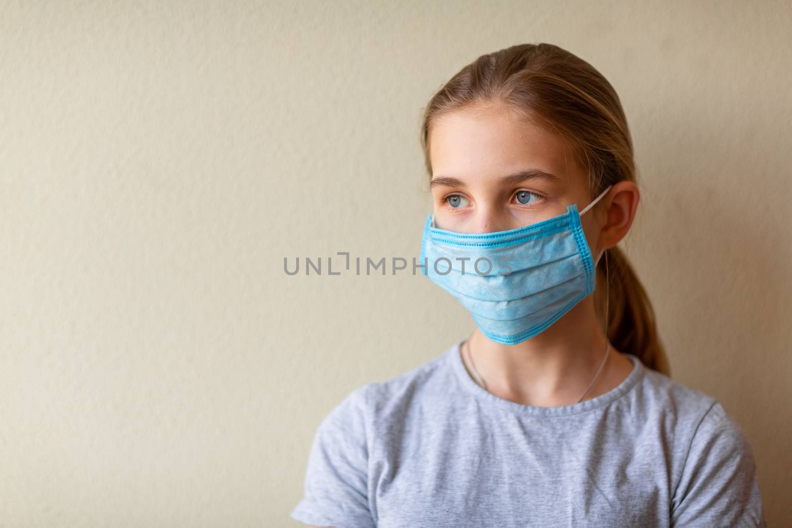 Little teenage girl in medical mask sad and scared. Coronavirus protection, wearing masks concept