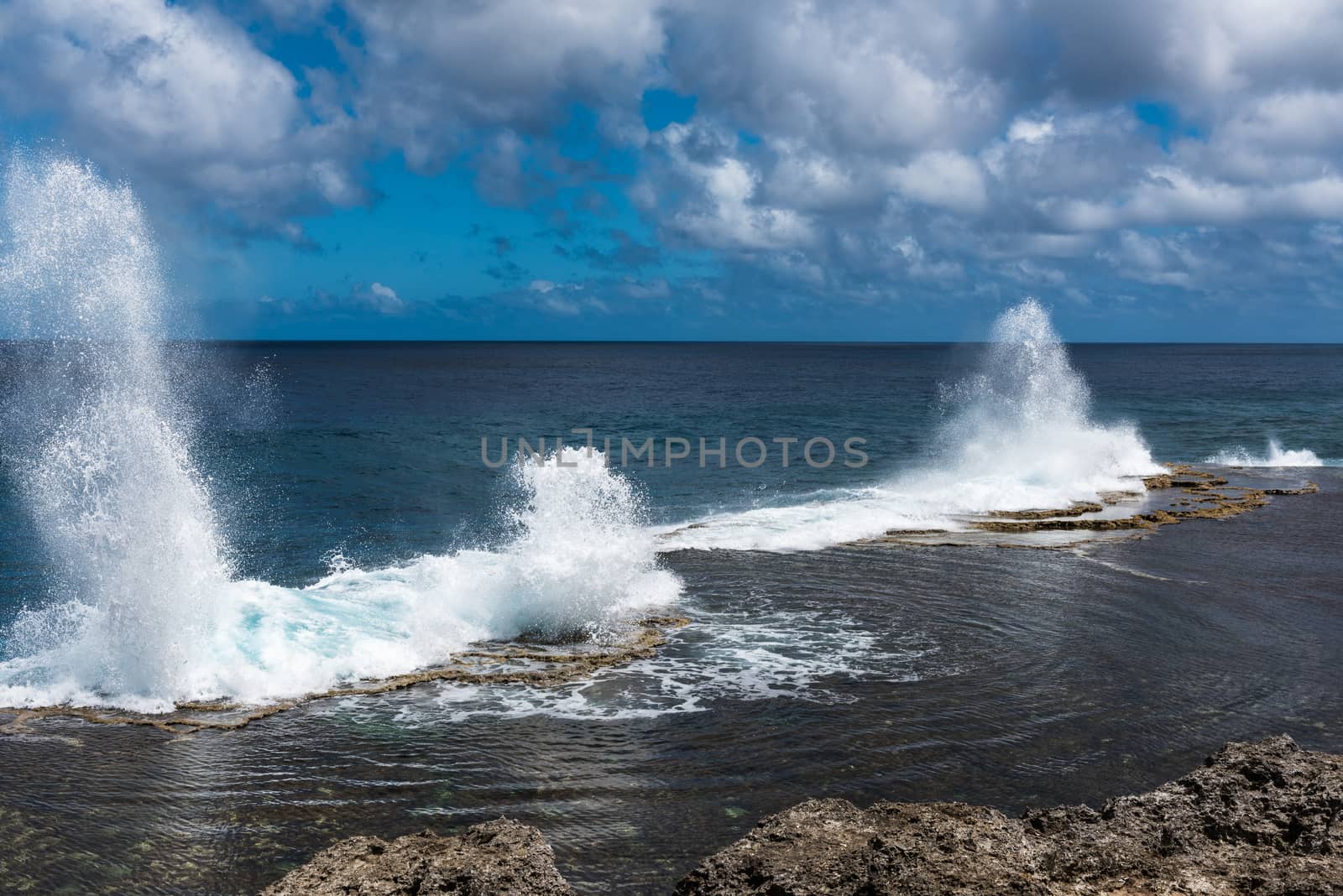 Water shoots to the sky from blowholes on the coastline of Alofa in Tonga as the tide rolls in.