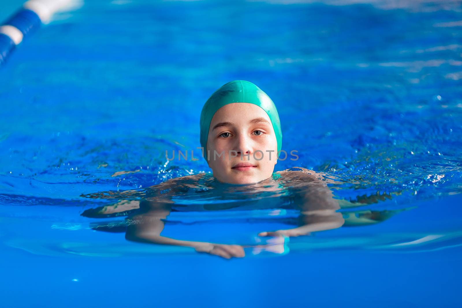 Cute little girl training in a swimming pool. Swimming sport for kids concept