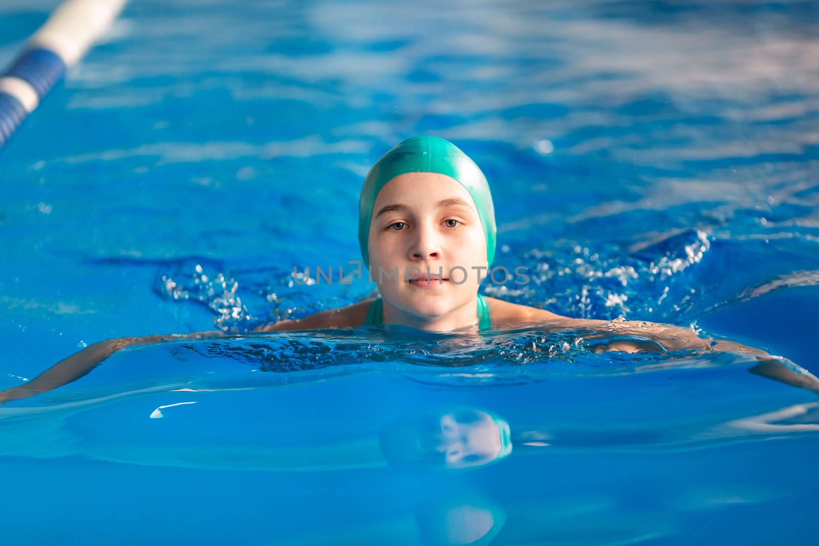 Cute little girl training in a swimming pool. Swimming sport for kids concept