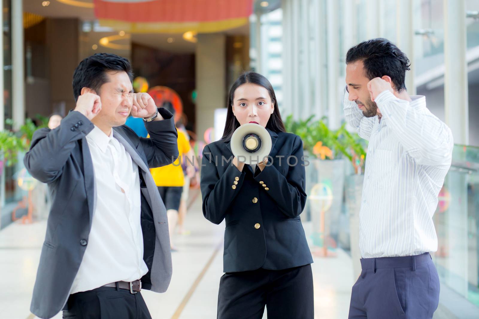 Young business woman working at the office, 
shouting and yelling in megaphone
