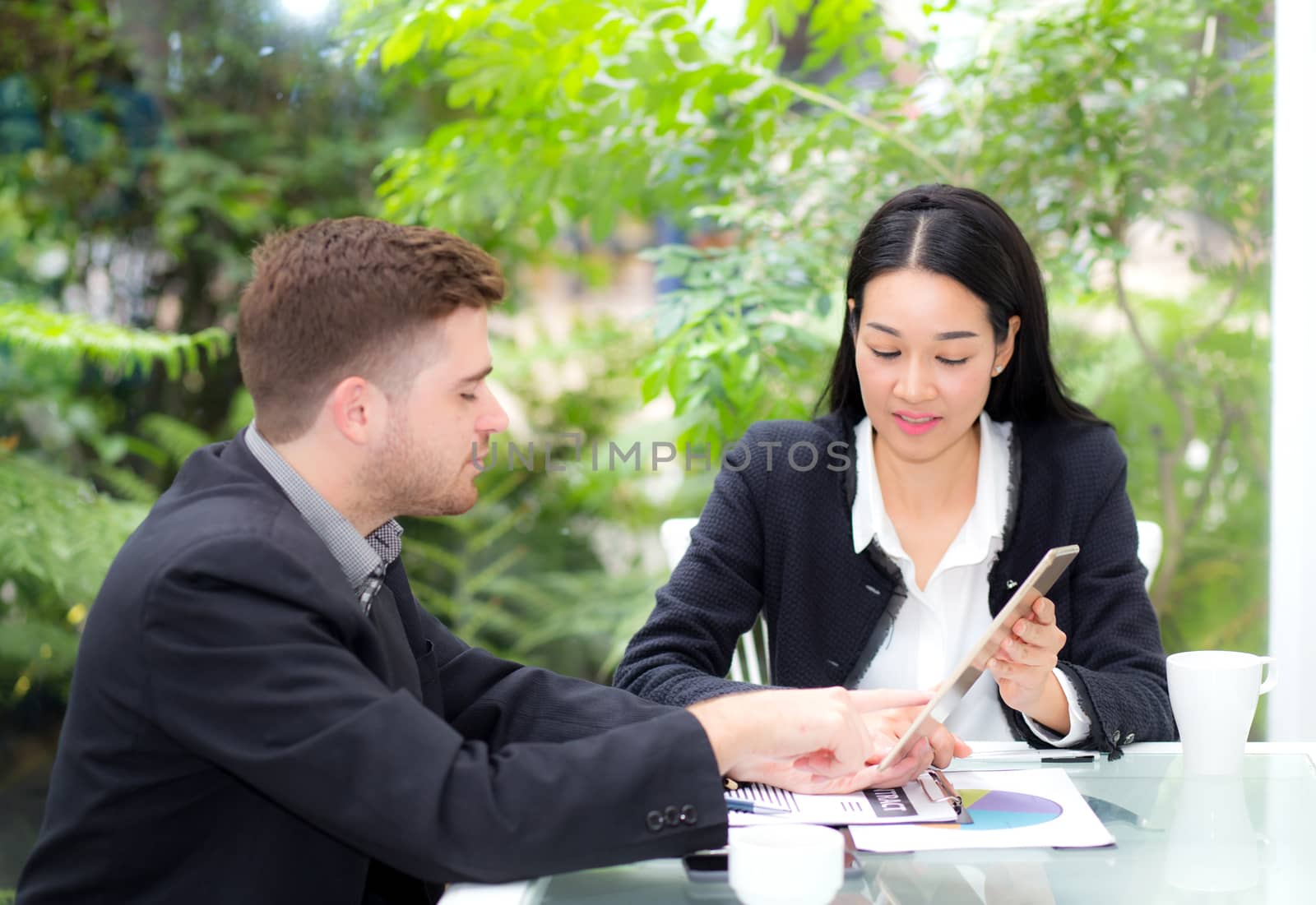 business man and woman people making meeting and looking at tablet for analyzing marketing working at office on desk.