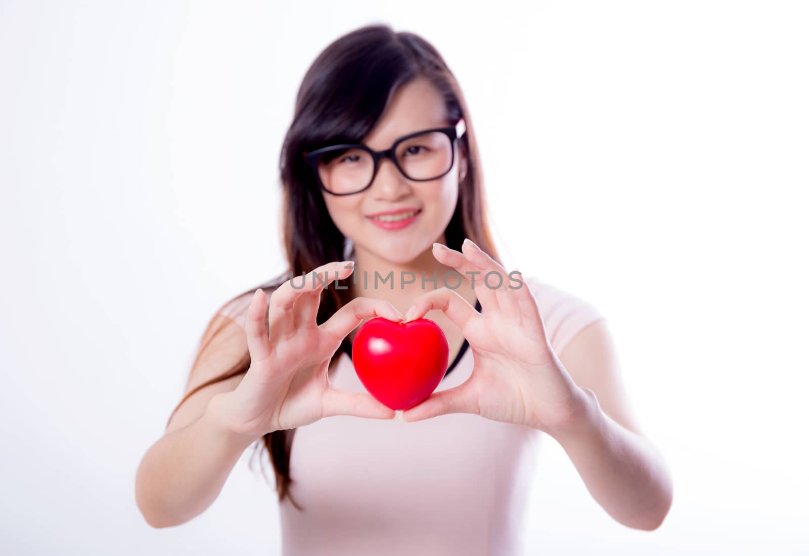 Young asian woman show heart hand sign on white background.