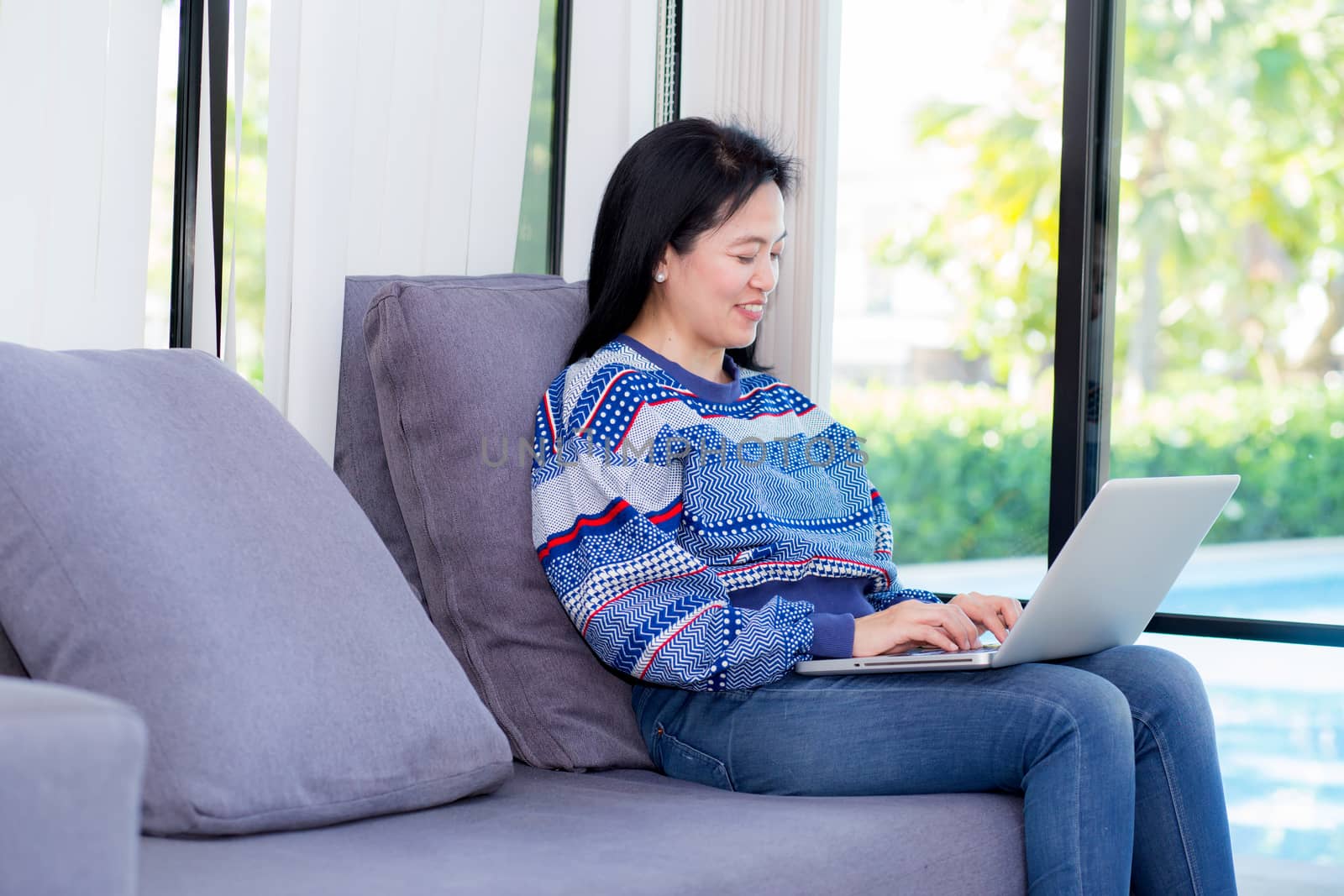 Closeup computer notebook on sofa with asian woman for work in lifestyle of woman concept