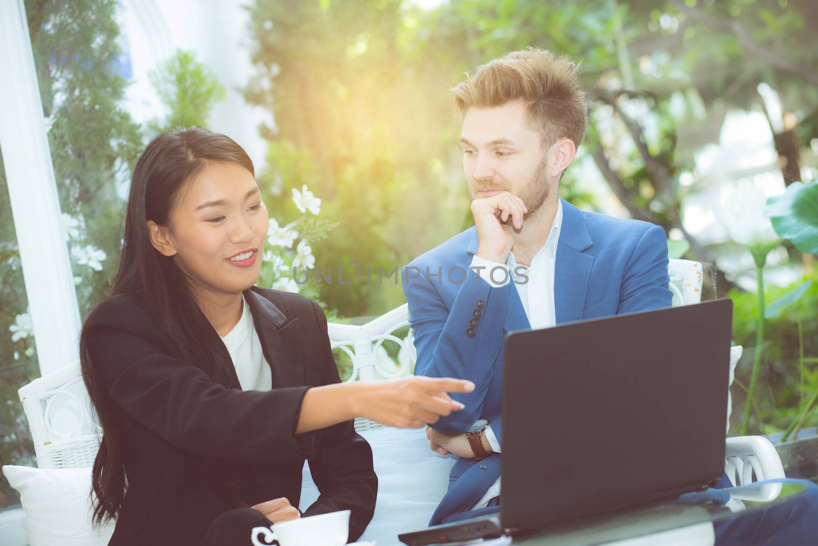 technology and office concept - two business man and woman with laptop - tablet pc computer and papers having discussion in office.