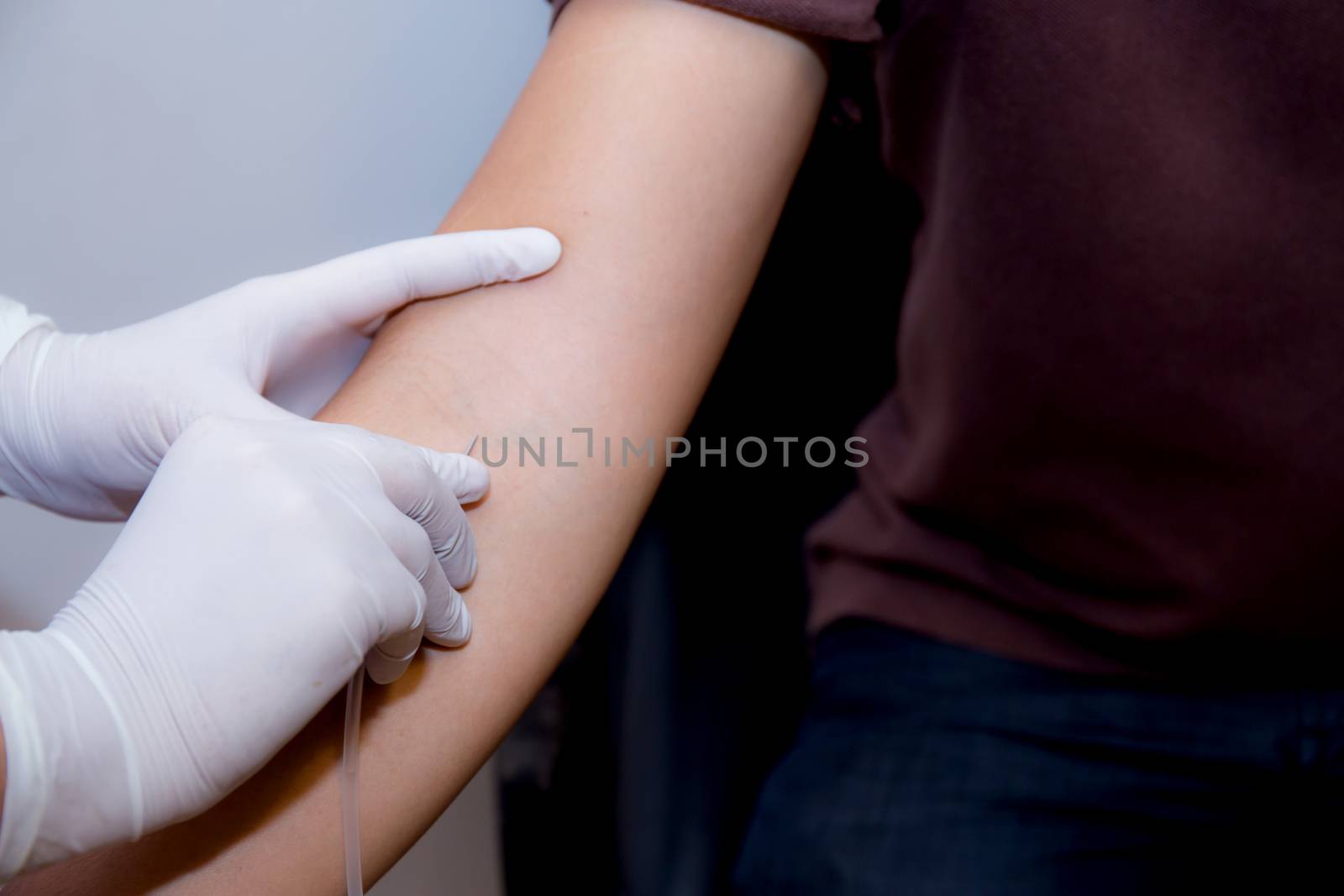 nurse putting an IV needle into a patients hand.