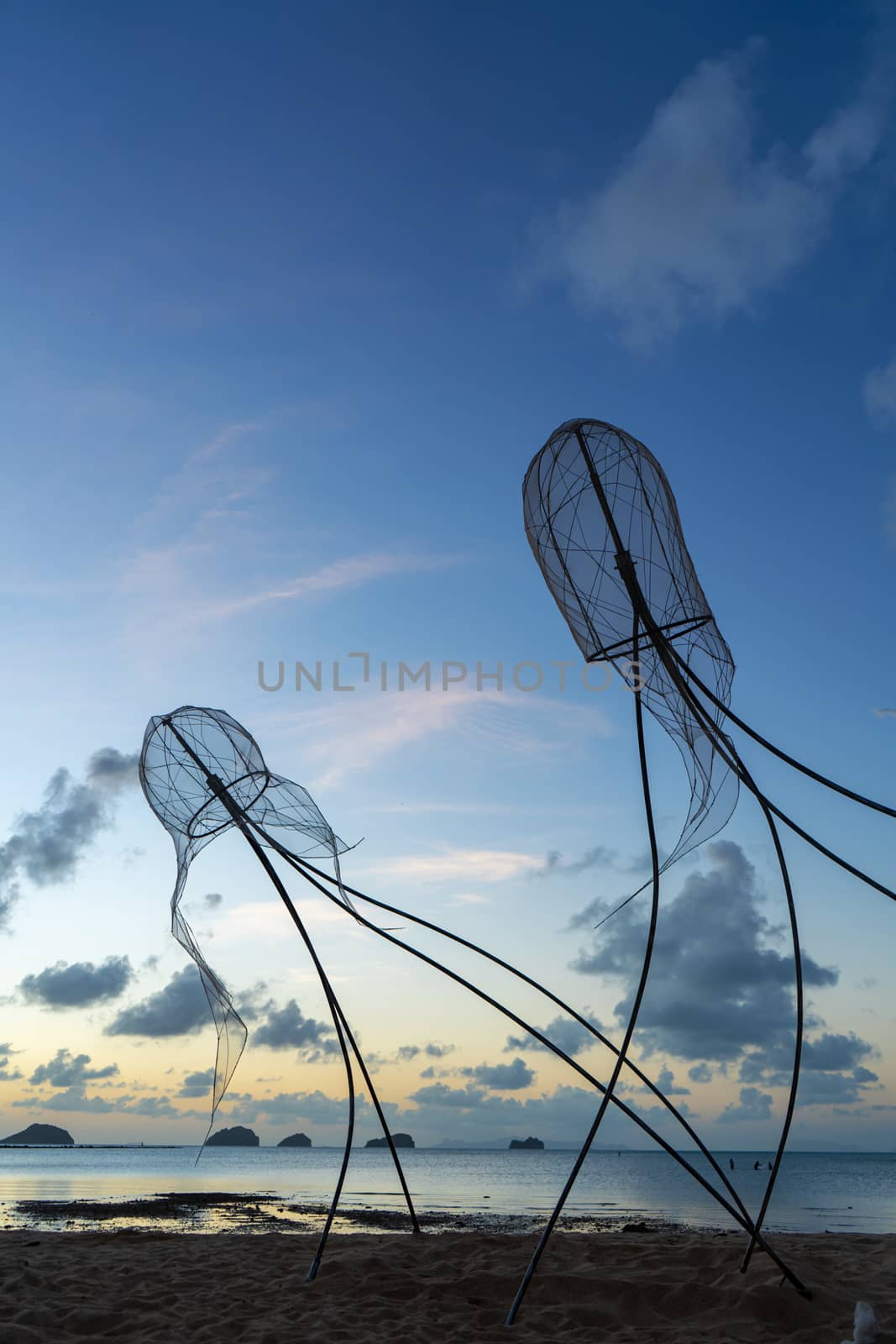 Figures of jellyfish on a background of a sunset sky..