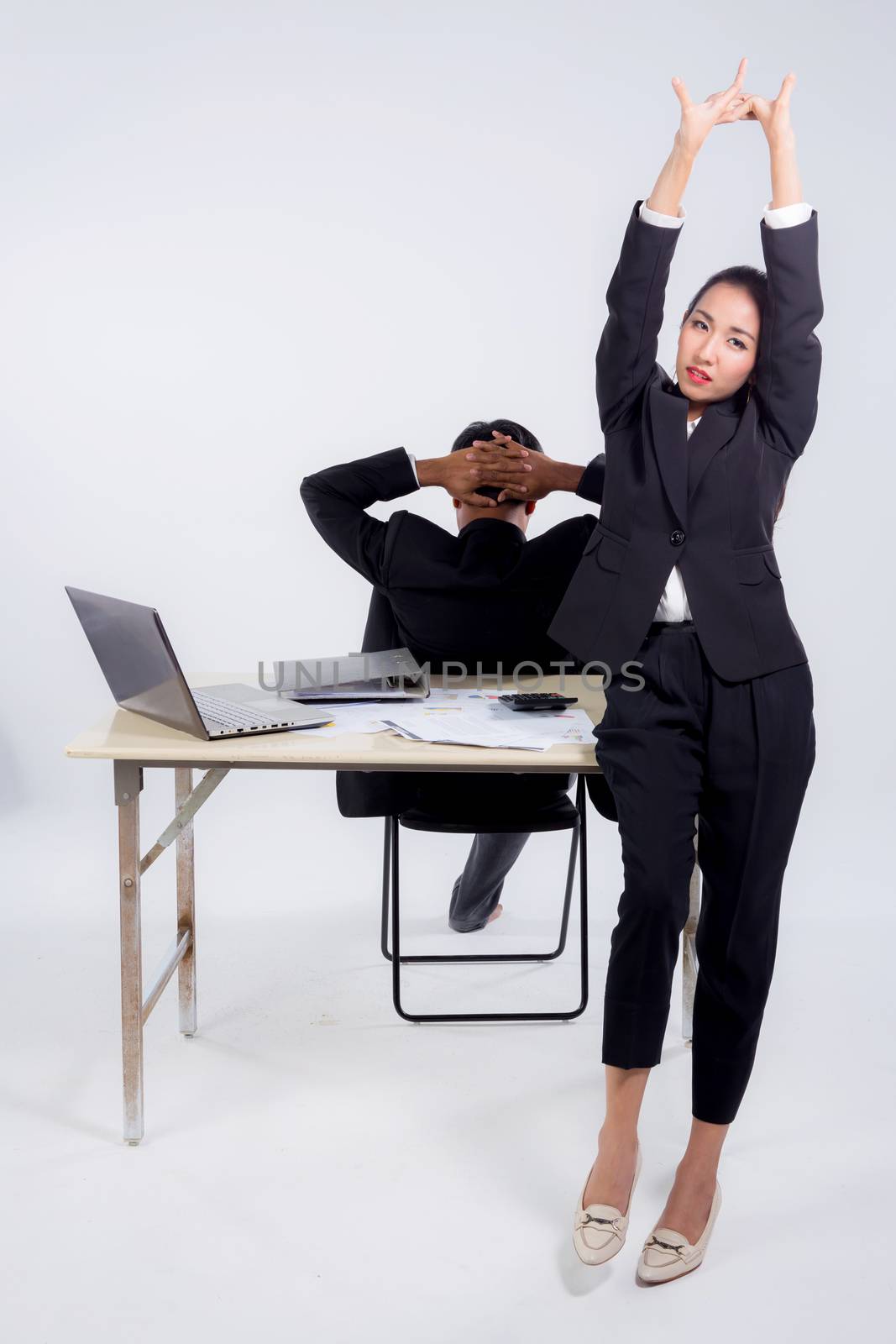Confident businesswoman and businessman in office with stretch in office.
