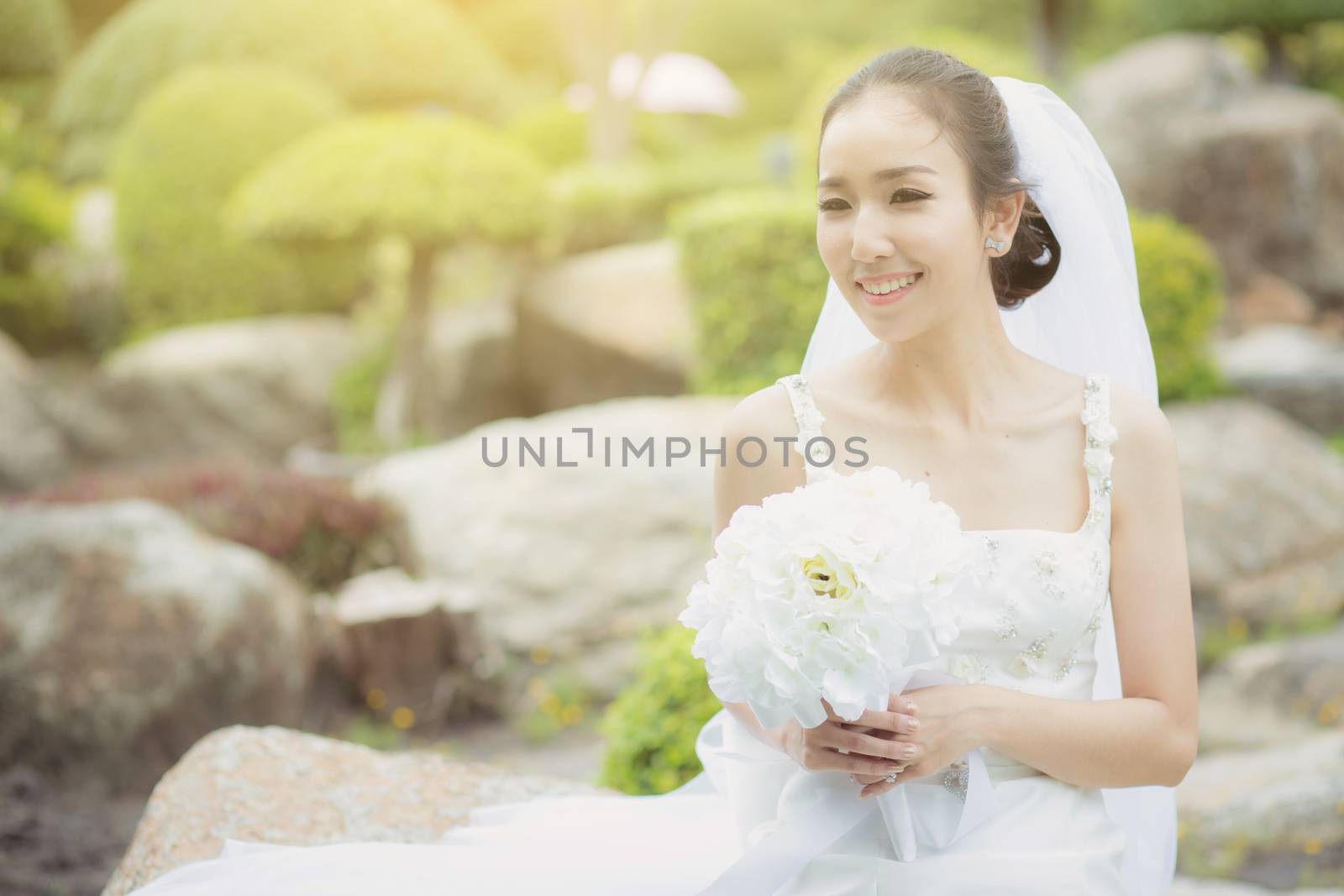 beautiful young woman on wedding day in white dress in the garden. Female portrait in the park - Selective focus.