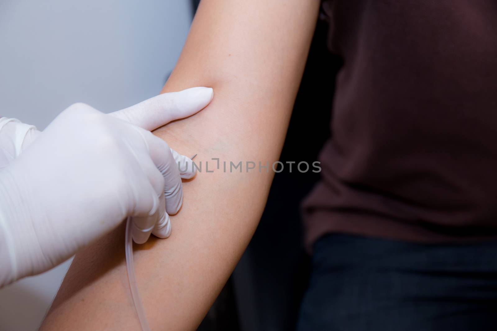 nurse putting an IV needle into a patients hand.