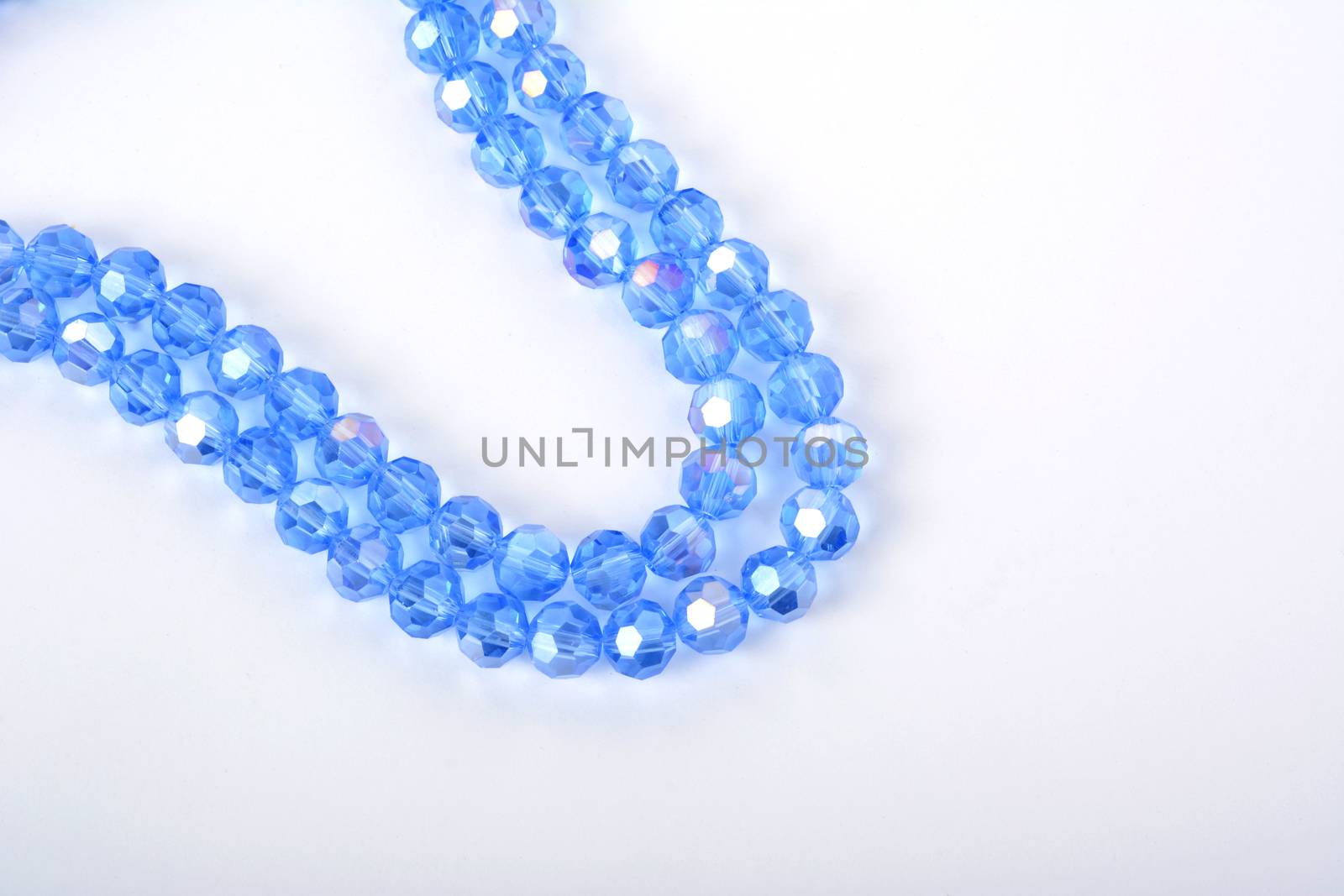 Beautiful Light Blue Glass Sparkle Crystal Isoalted Beads on white background. Use for diy beaded jewelry. Space for text