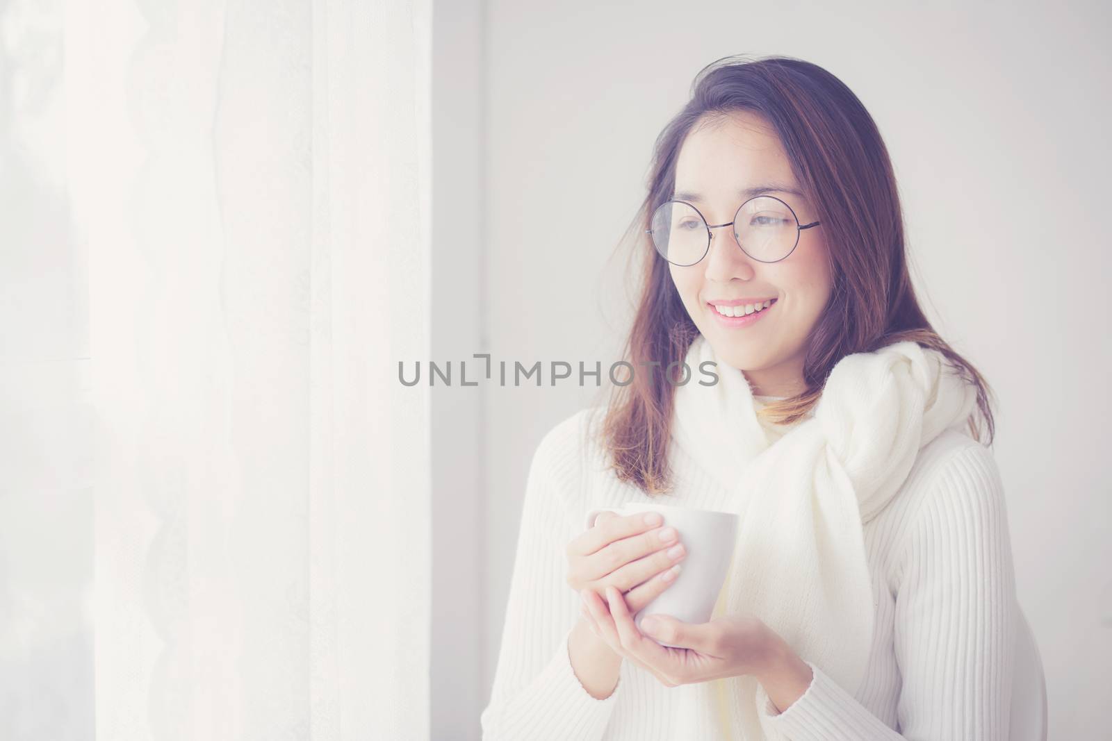 Portrait of bedroom concept: asian woman holding a cup of coffee with on bedroom in breakfast time.