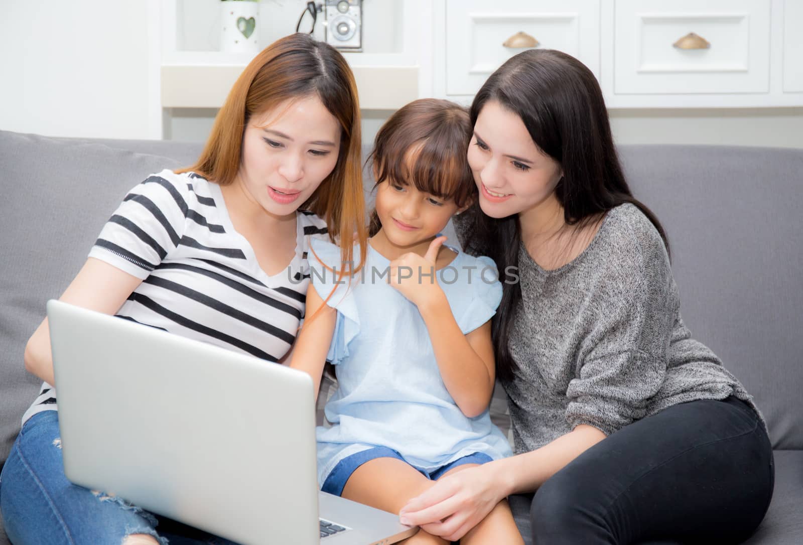 Mother, Aunt and kid having time together lerning with using lap by nnudoo