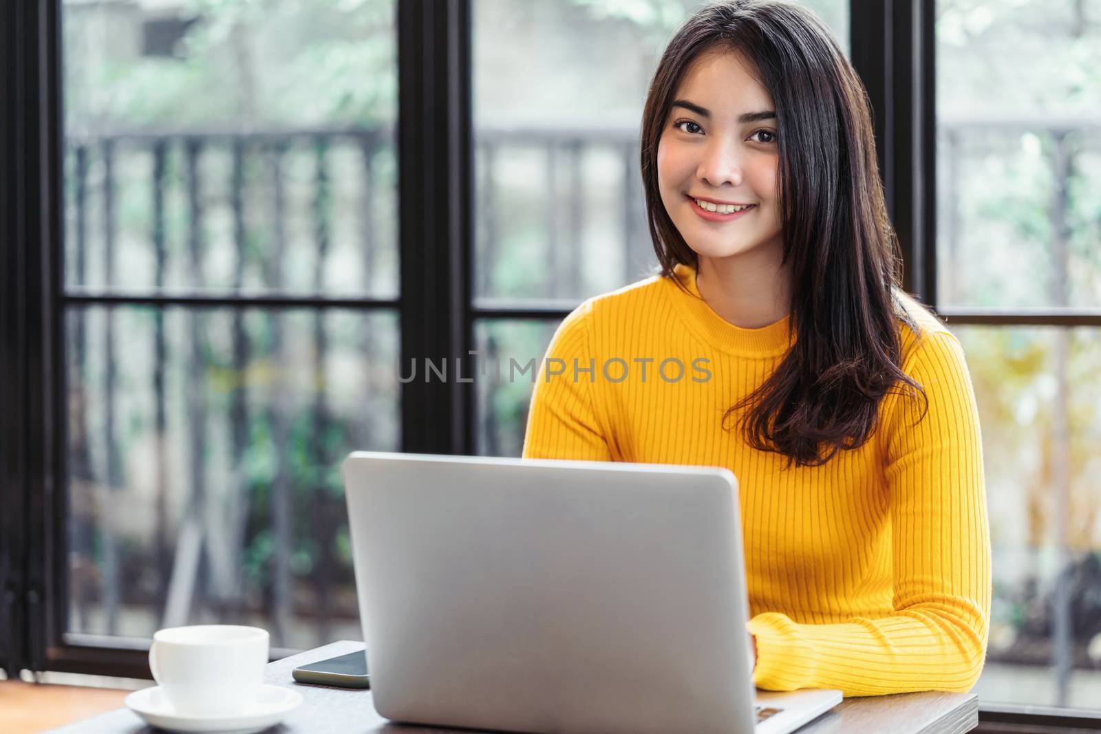 Young Asian woman working with laptop for online shopping in coffee shop or coworking space, technology money wallet and online payment concept,