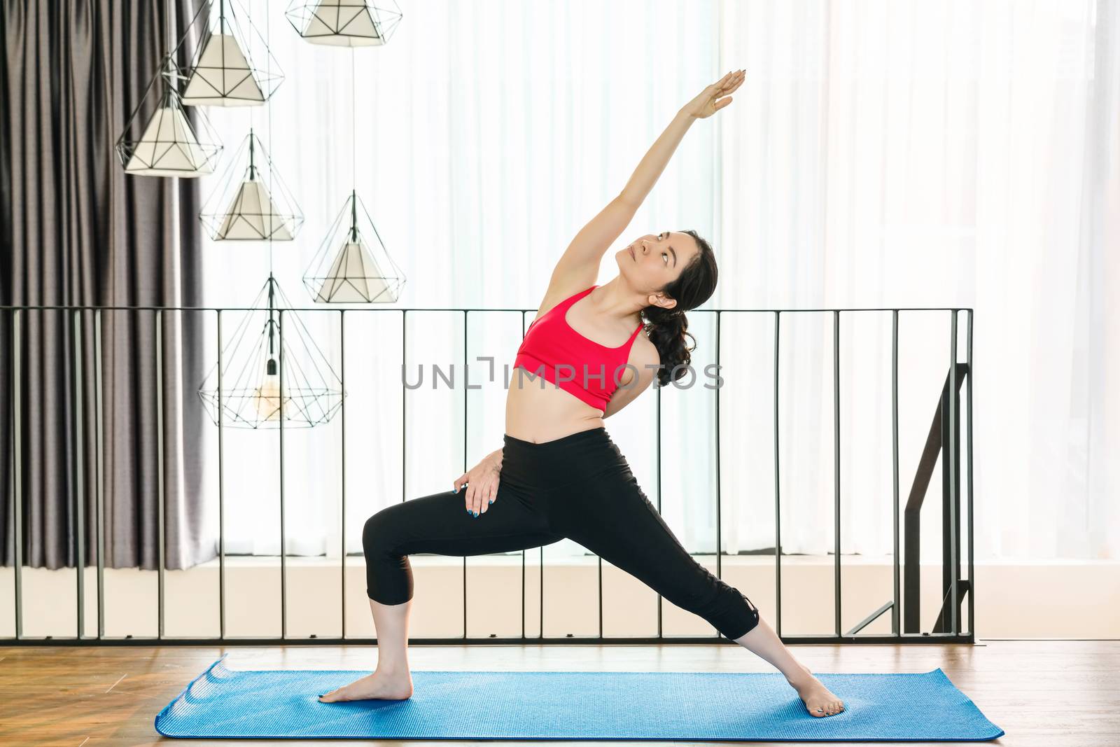 Asian woman practicing yoga from home when Covid19 outbreak and lockdown, healthy or Meditation Exercise, yoga workout at home, coronavirus pandemic and quarantine, sports and healthcare concept