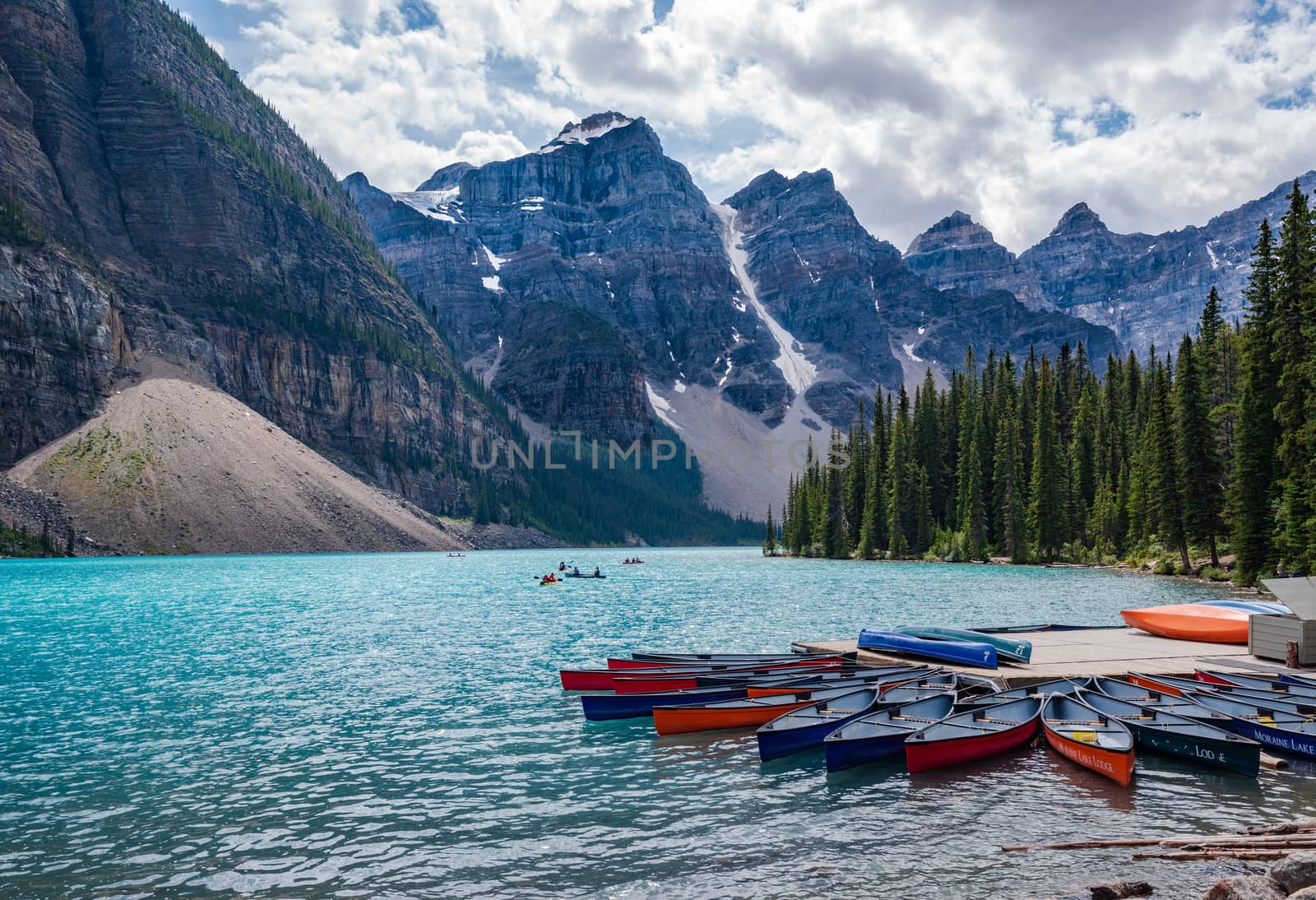 Banff, Canada--August 6, 2018.  Wide angle shot of Boaters on the aqua waters of Moraine Lake surrounded by the Ten Peaks.