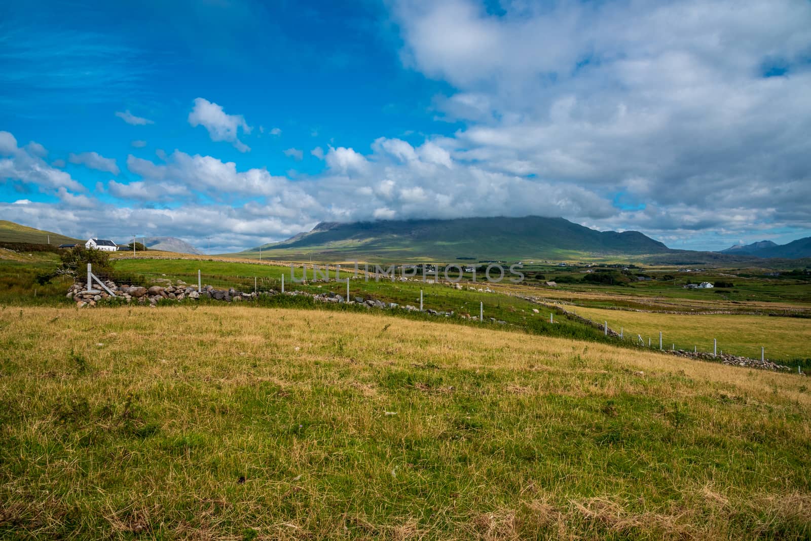 Wide angle landscape photo of the rolling hills and valleys of County Mayo, Ireland near the coast.