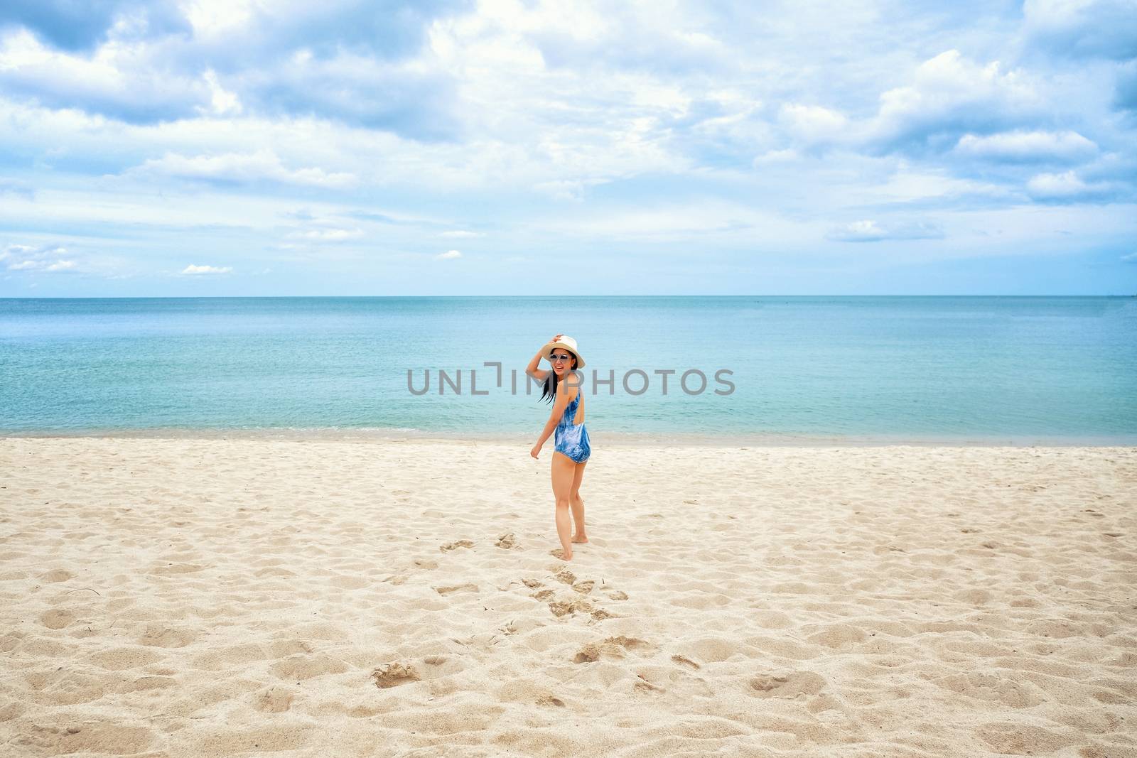 Young happy woman running on the beach by Surasak