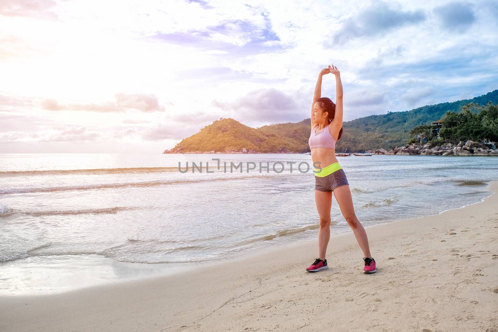 Runner woman running on beach in sunrise