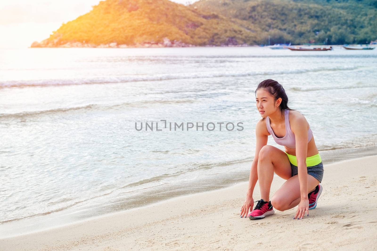 Runner woman running on beach in sunrise