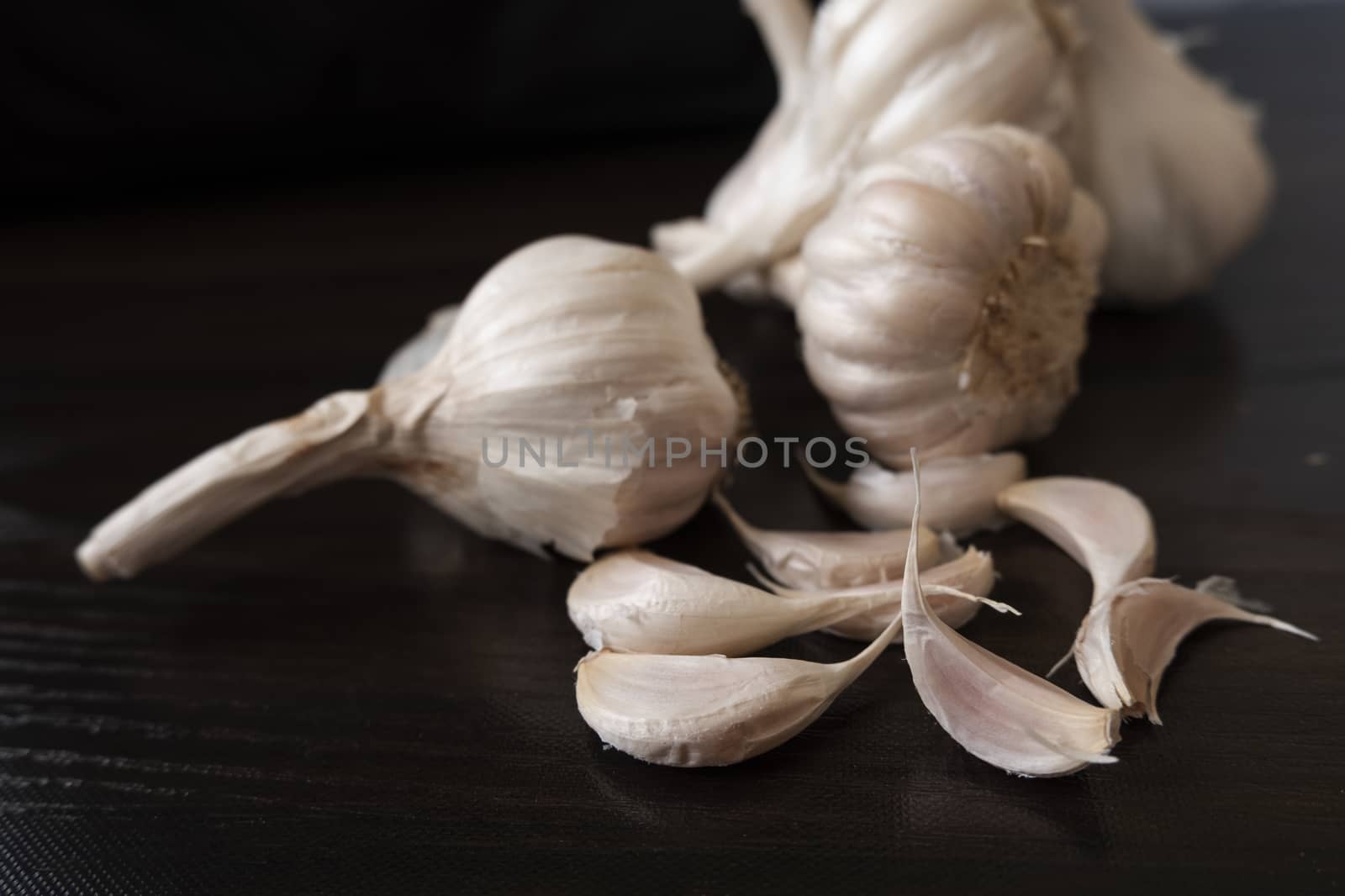 a closeup shot of garlic's & cloves on wooden background