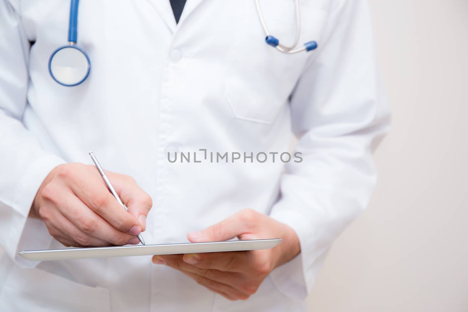 Doctor working on a digital tablet on white background.