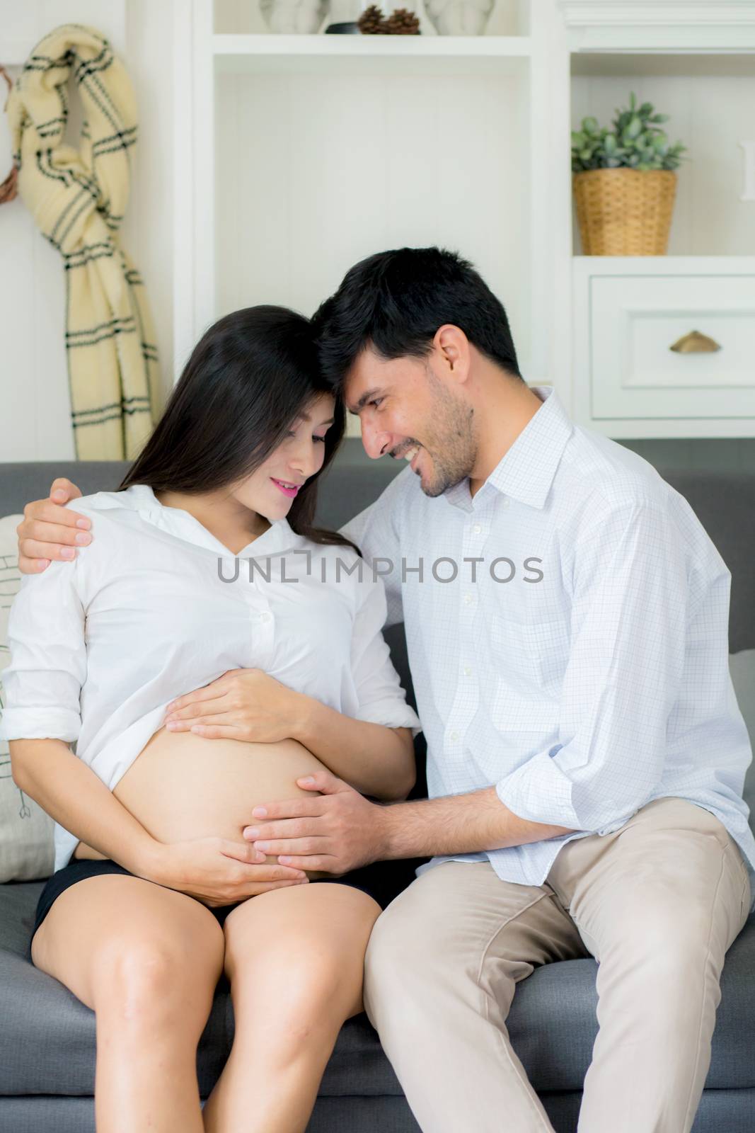 Beautiful pregnant asian woman and husband together care her pre by nnudoo
