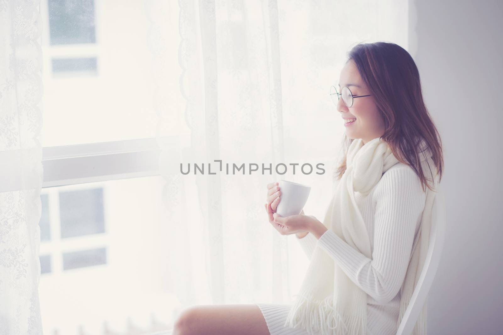 Portrait of bedroom concept: asian woman holding a cup of coffee with on bedroom in breakfast time.