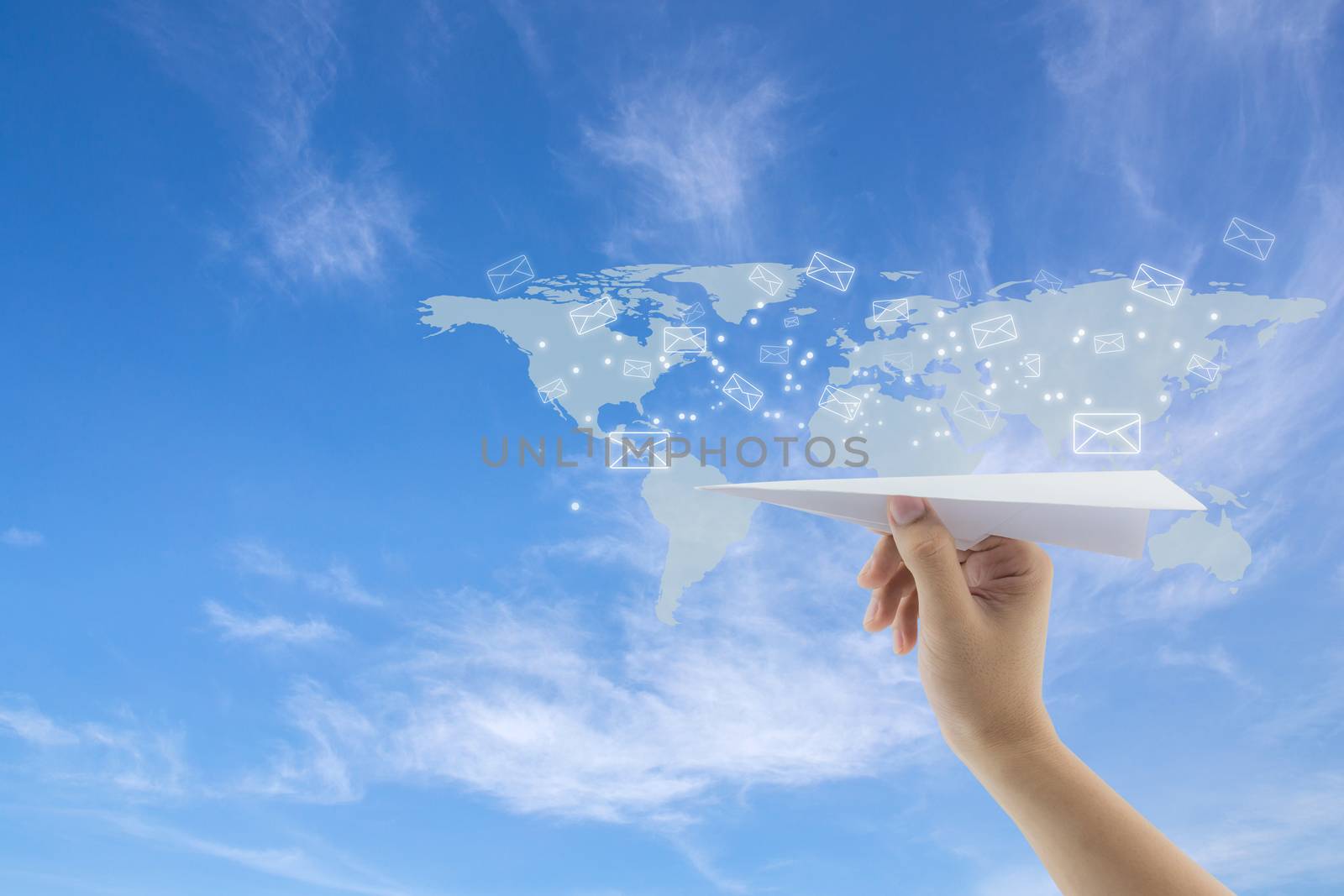 hand with paper plane against blue sky with sending message with email on world map, network communication concept.