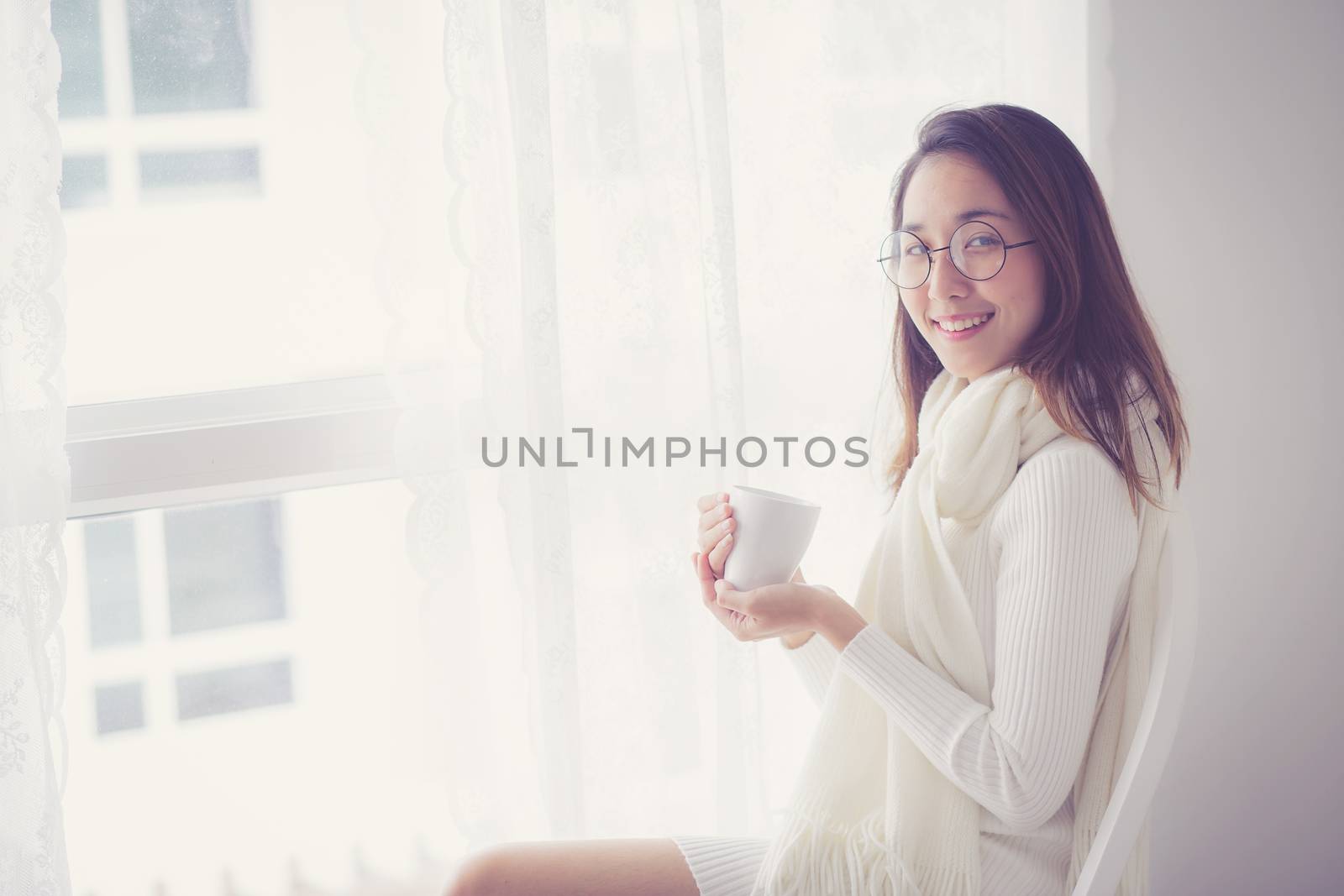 Portrait of bedroom concept: asian woman holding a cup of coffee with on bedroom in breakfast time.