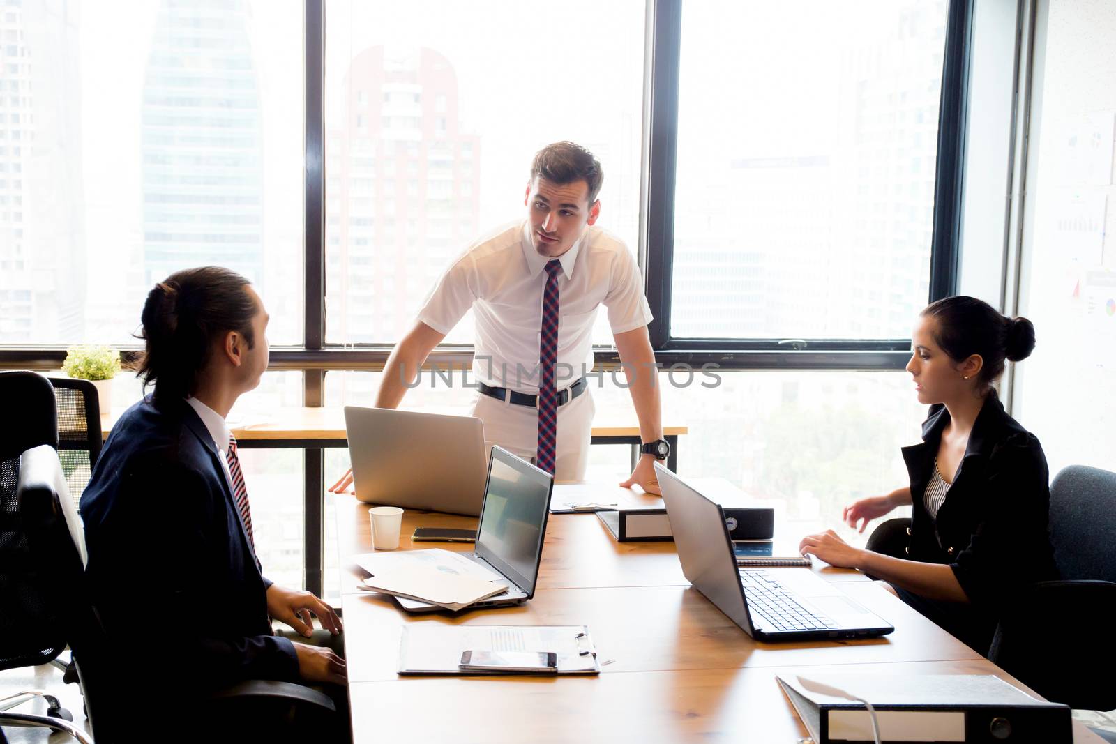 Businesspeople with leader discussing together in conference room during meeting at office.