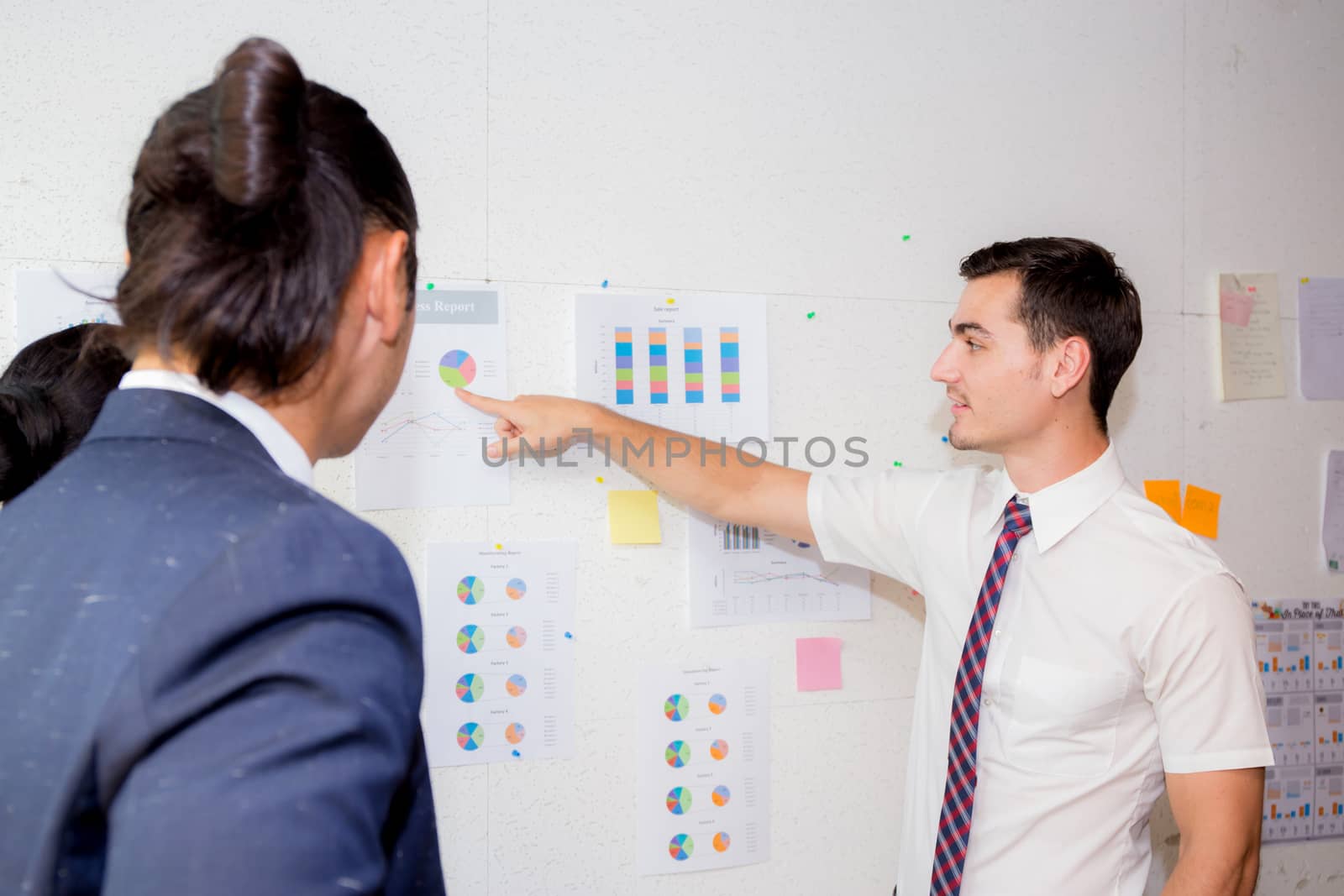 three business people in modern office looking report and analyzing with talking in meeting room.