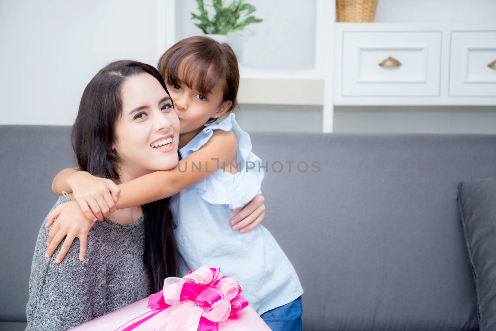 happy of mother and daughter asian with gift with pink ribbon and daughter kissing mother, Happy family concept. Happy mother's day.