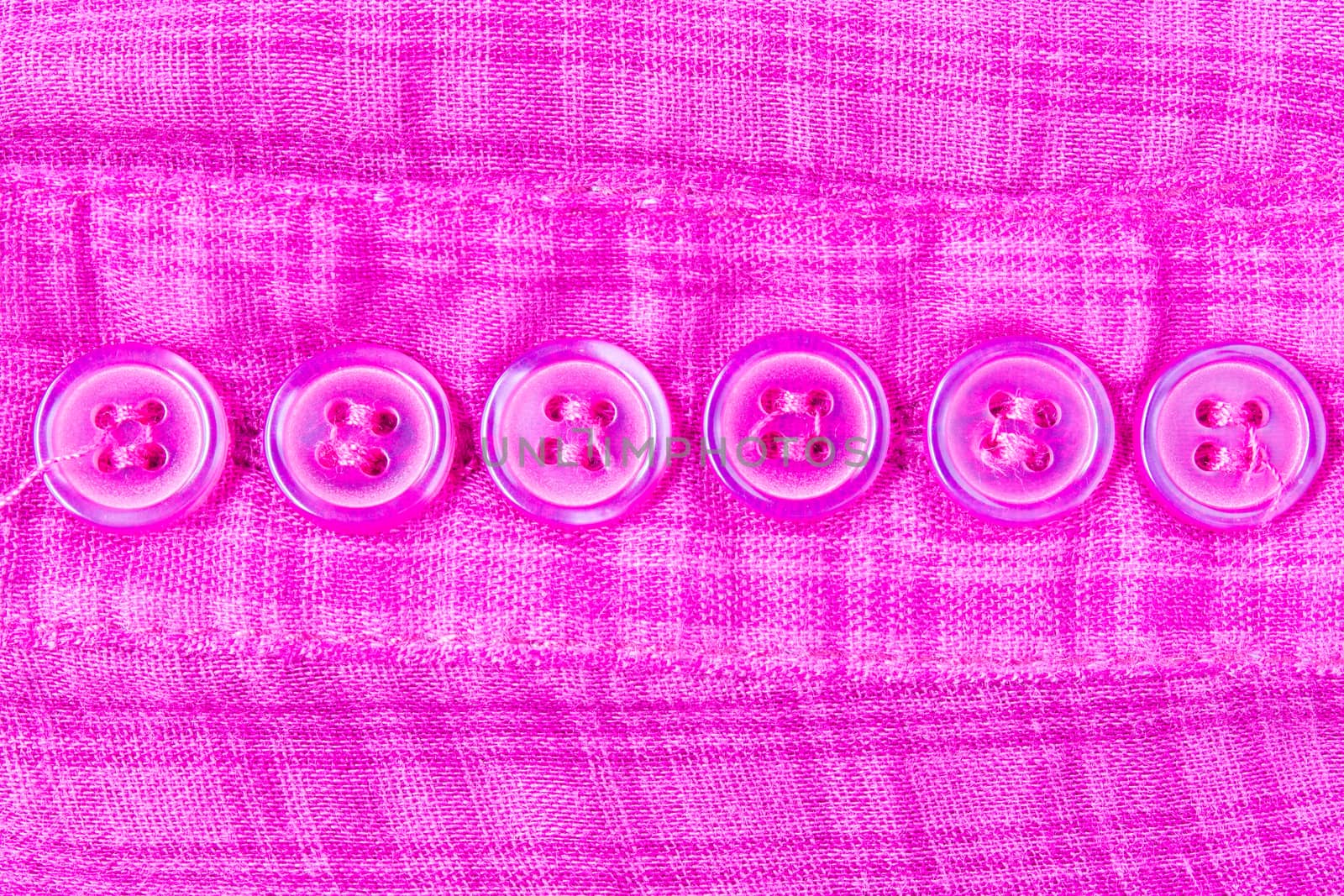 Purple button on scott fabric texture. Button of violet apparel background.