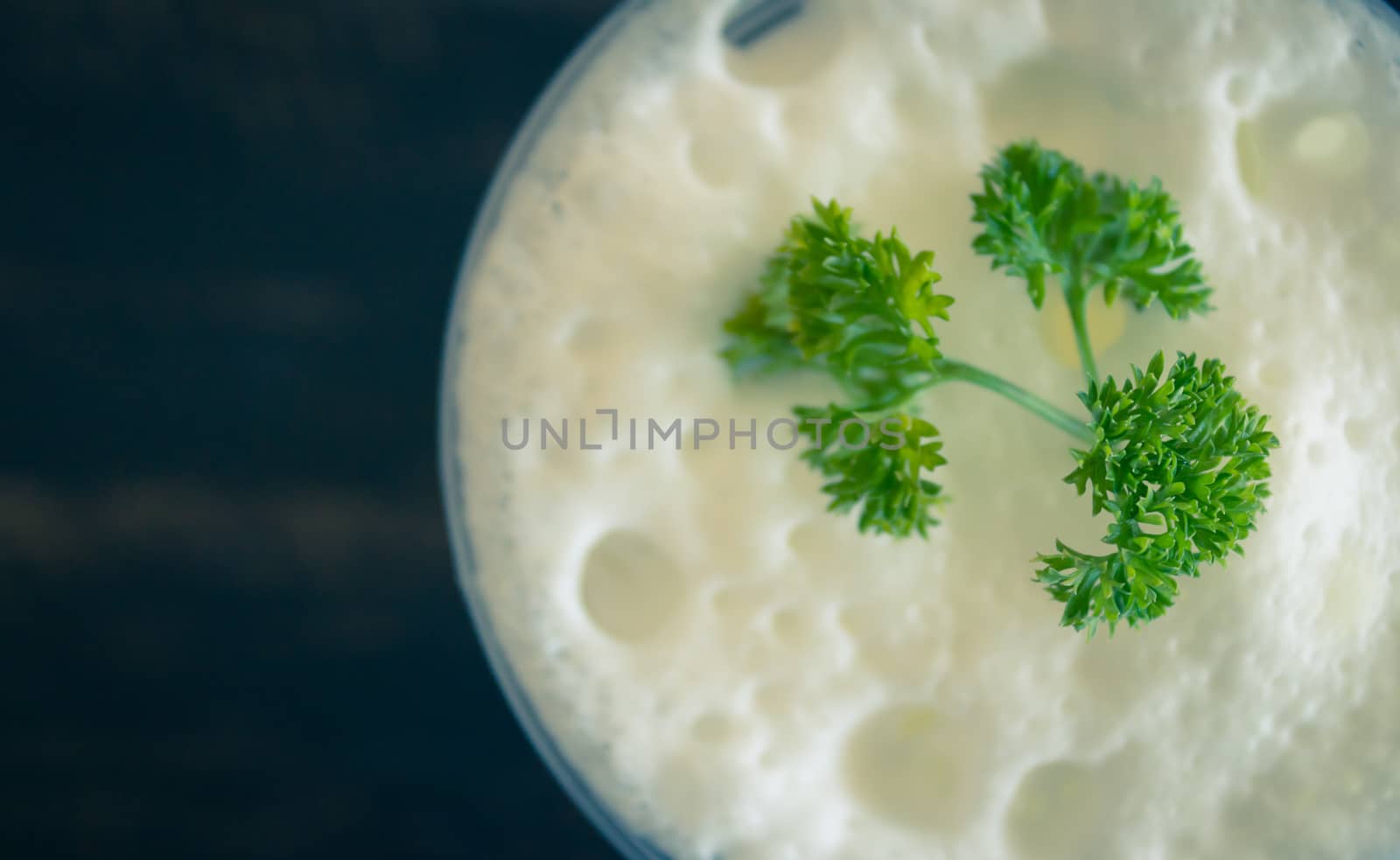 Milk froth and Parsley on Black Wood Table Flatlay Half. Milk froth in plastic glass. Milk froth for food and drink category