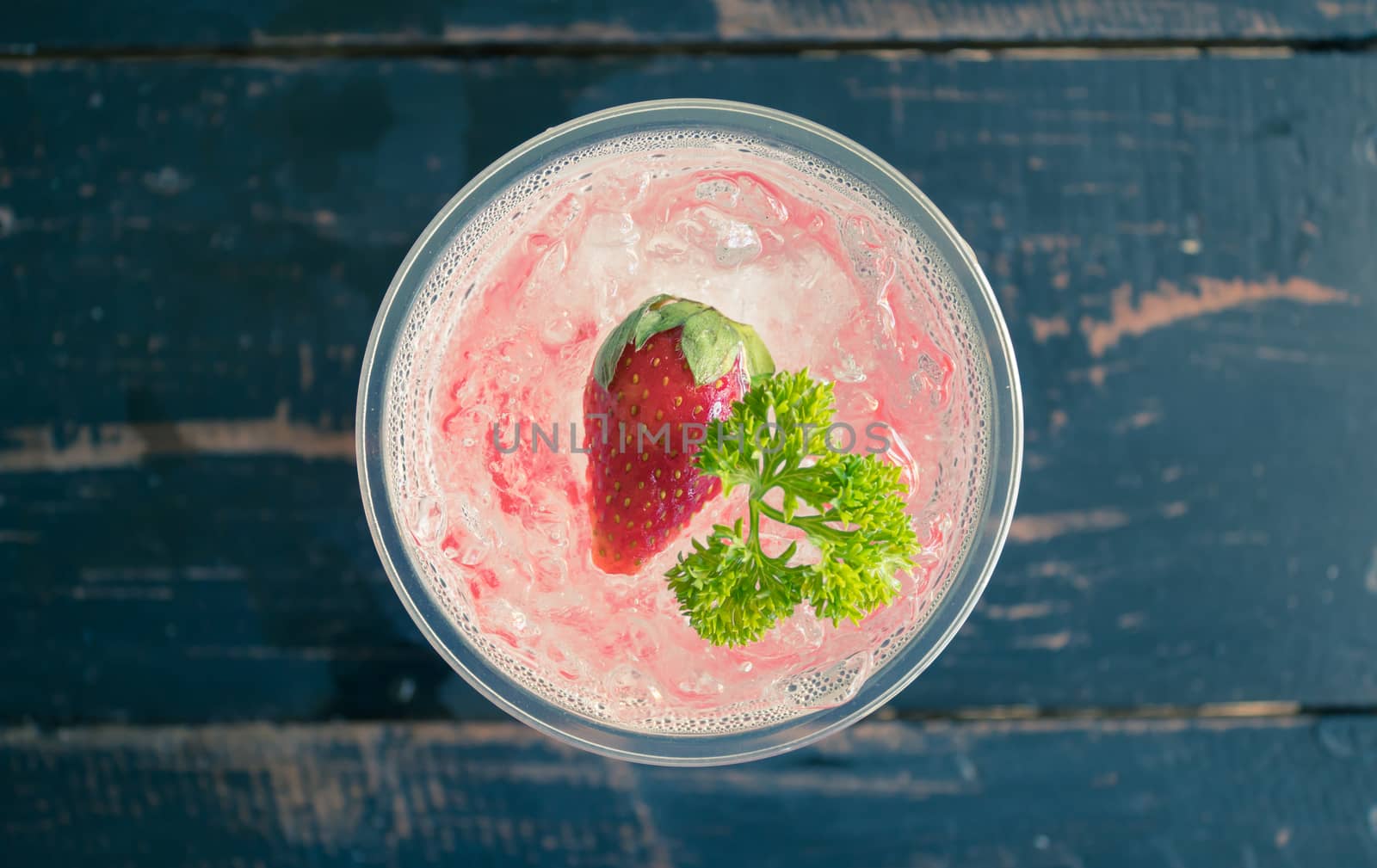 Red Italian Soda Cold Beverage and Strawberry Fruit and Parsley. Red Italian Soda Cold Beverage with strawberry fruit and ice in glass on wood table for food 
and drink category