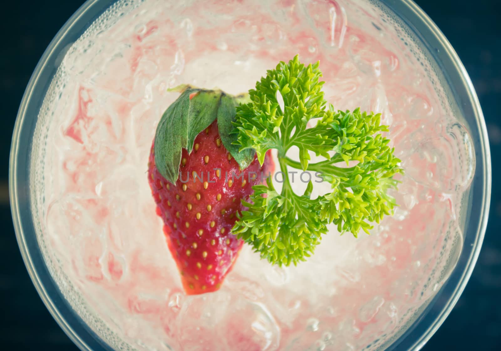 Red Italian Soda Cold Beverage and Strawberry Fruit and Parsley. Red Italian Soda Cold Beverage with strawberry fruit and ice in glass on wood table for food 
and drink category