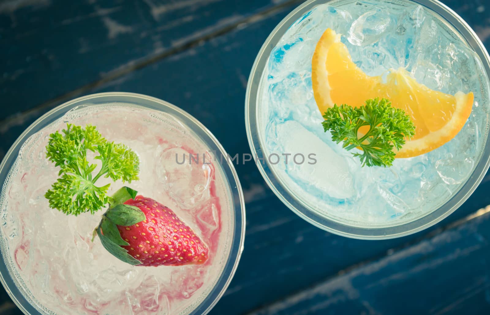 Blue Red Italian Soda Cold Beverage and Lemon Strawberry Fruit and Parsley. Blue Red Italian Soda Cold Beverage on wood table for food and drink category