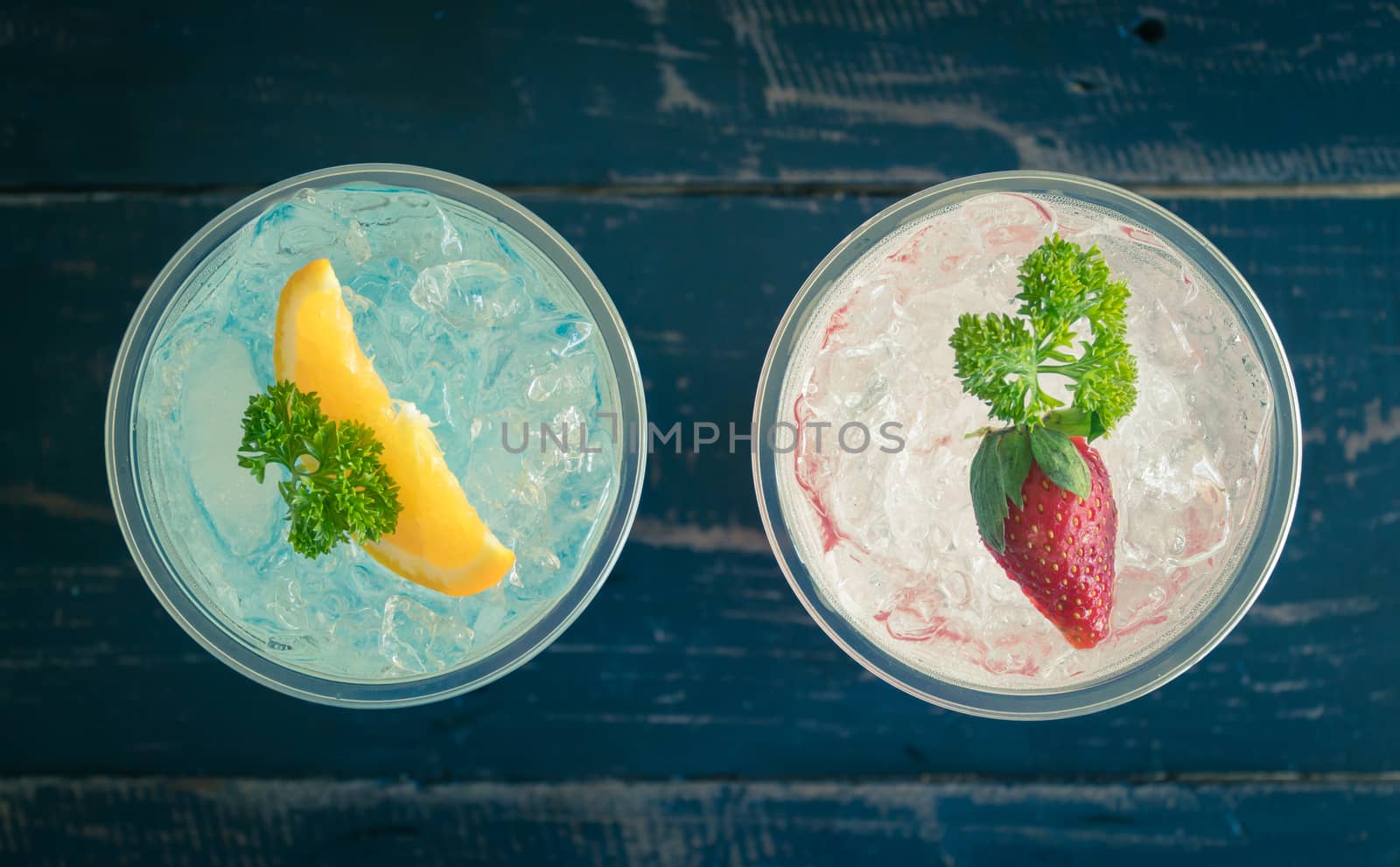 Blue Red Italian Soda Cold Beverage and Lemon Strawberry Fruit and Parsley. Blue Red Italian Soda Cold Beverage on wood table for food and drink category