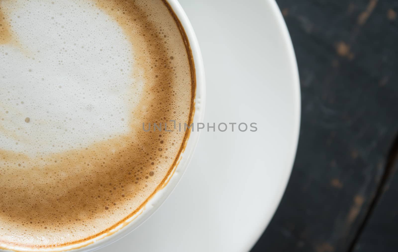 Flatlay Half Heart Shape Froth Milk Latte Art in White Coffee Cup on Black Wood Table. Heart shape froth milk Latte art hot beverage for coffee lover